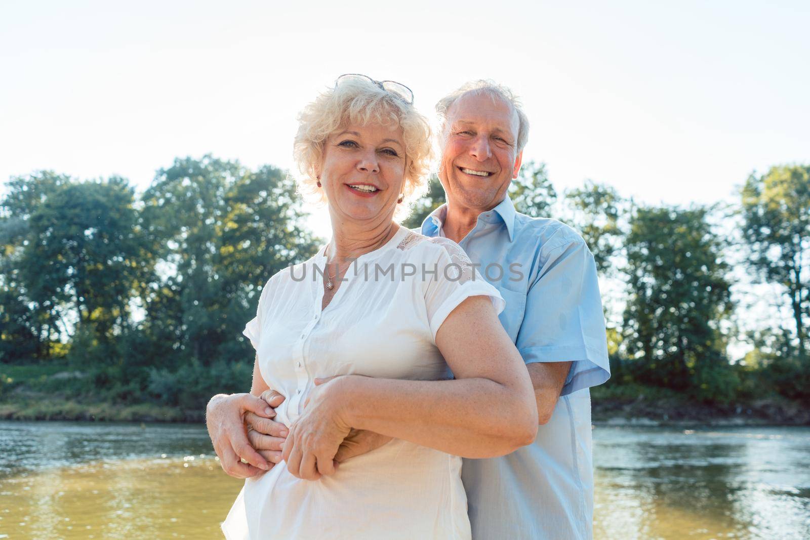 Low-angle side view portrait of a romantic senior couple in love enjoying a healthy and active lifestyle outdoors in summer