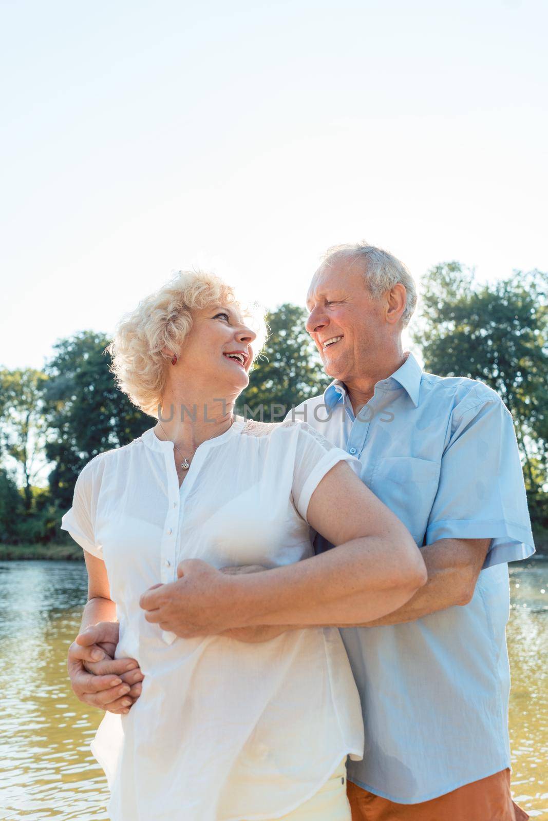 Low-angle side view portrait of a romantic senior couple in love enjoying a healthy and active lifestyle outdoors in summer