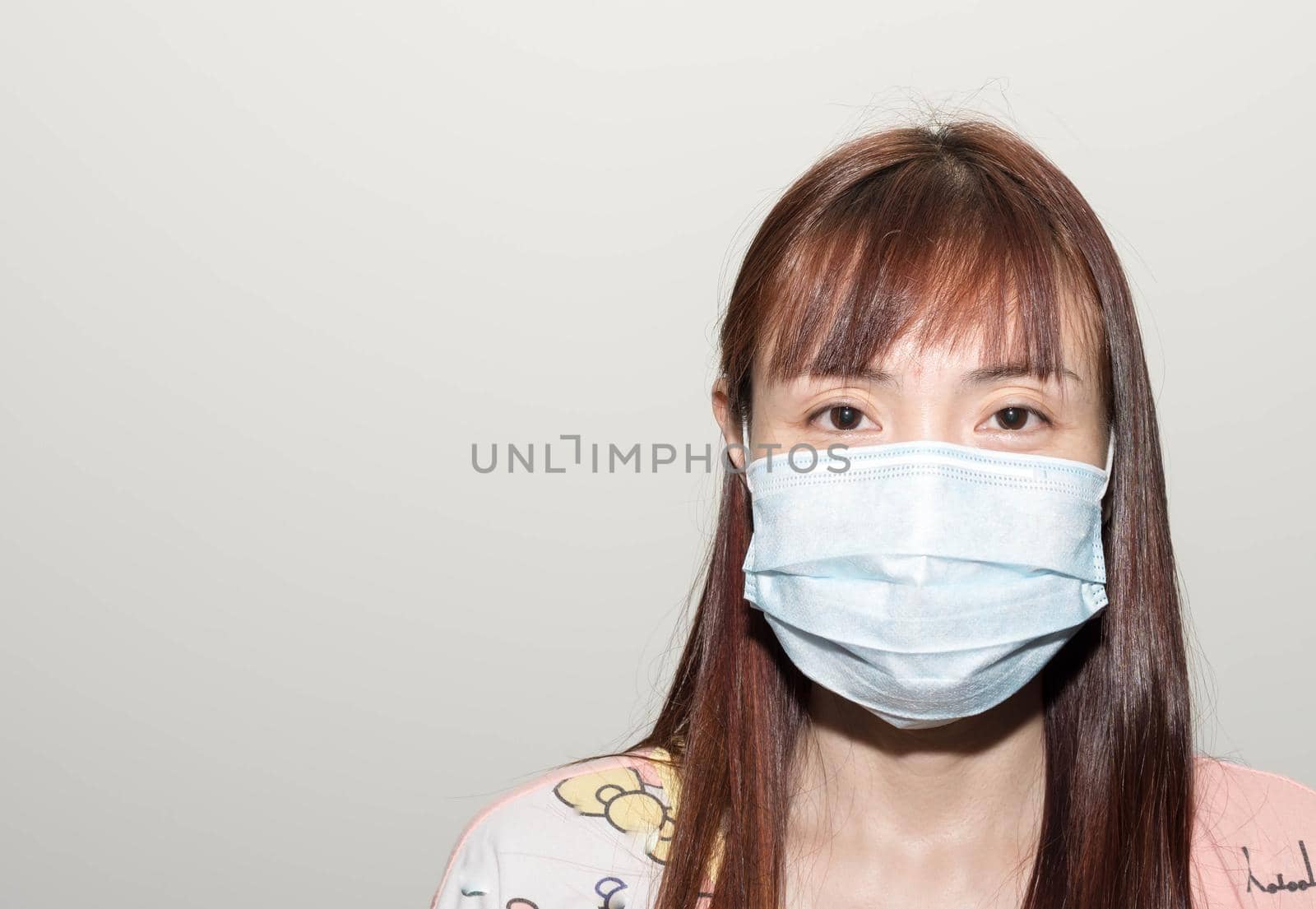 Female asian wearing a mask to protect her against the corona virus.
