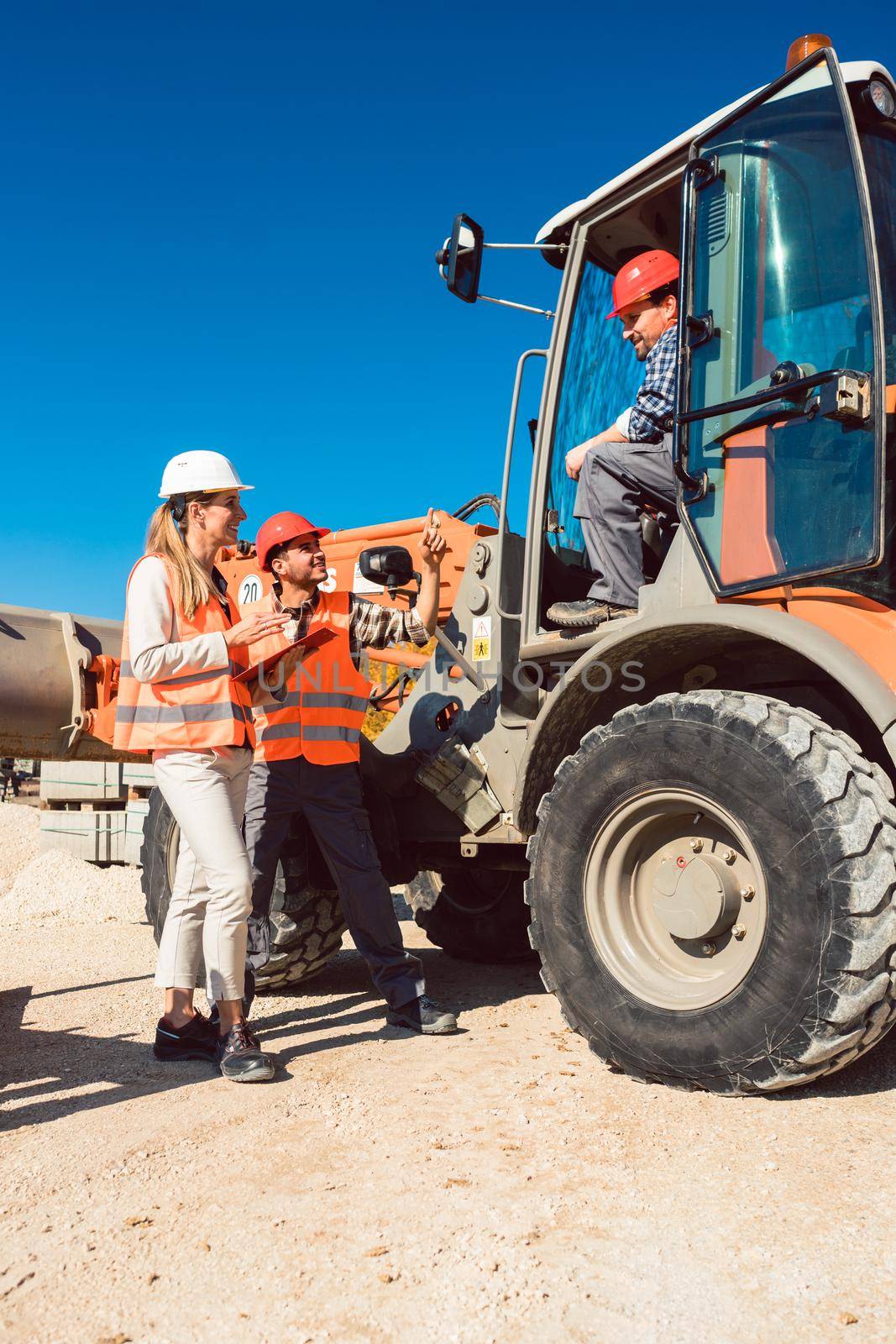 Civil engineer and worker discussion on road construction site, woman and man