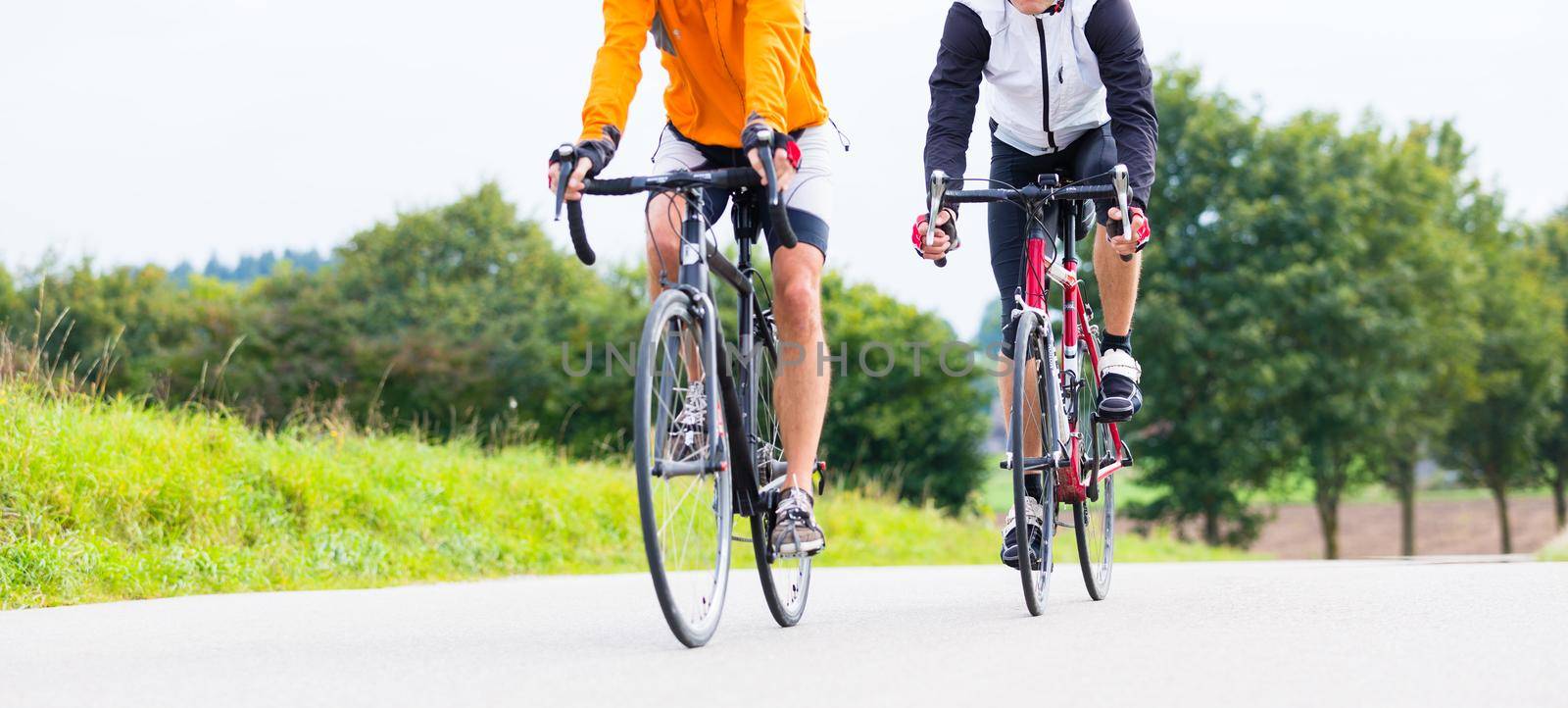 Two bicyclists doing sport with their bikes having a sport race, crop