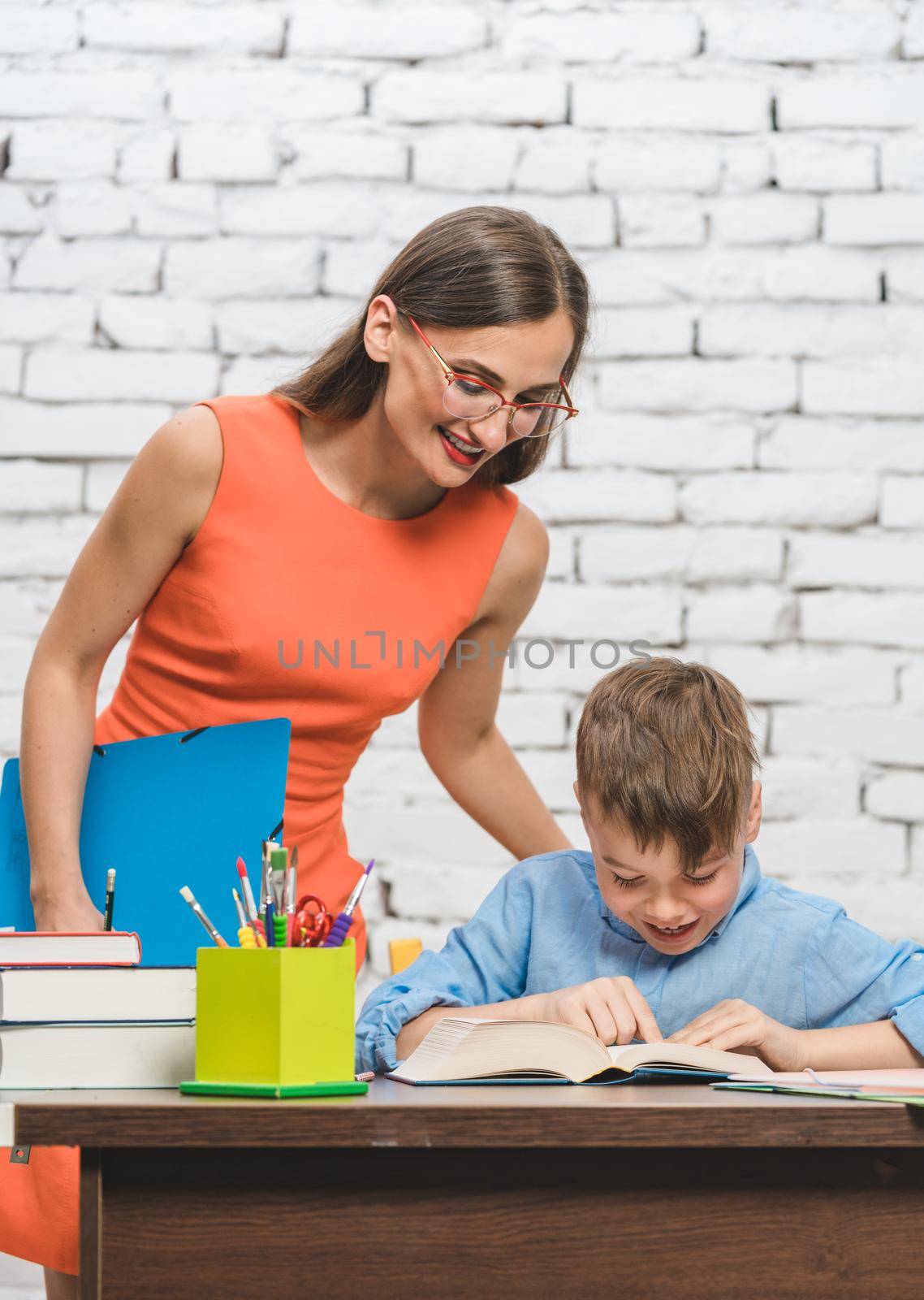 Mother helping her son to do the school homework assignment