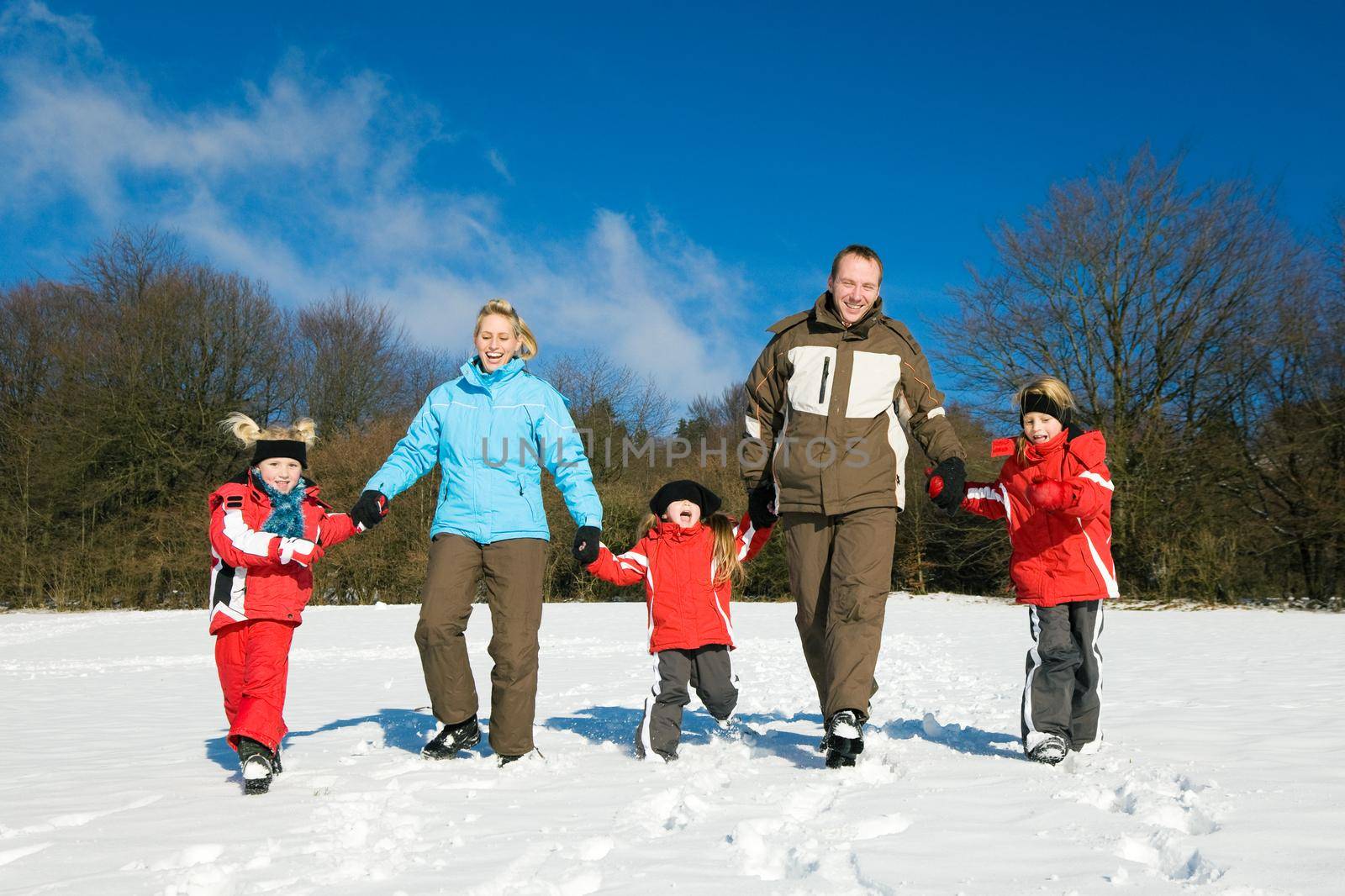 Active family having a winter walk in the snow