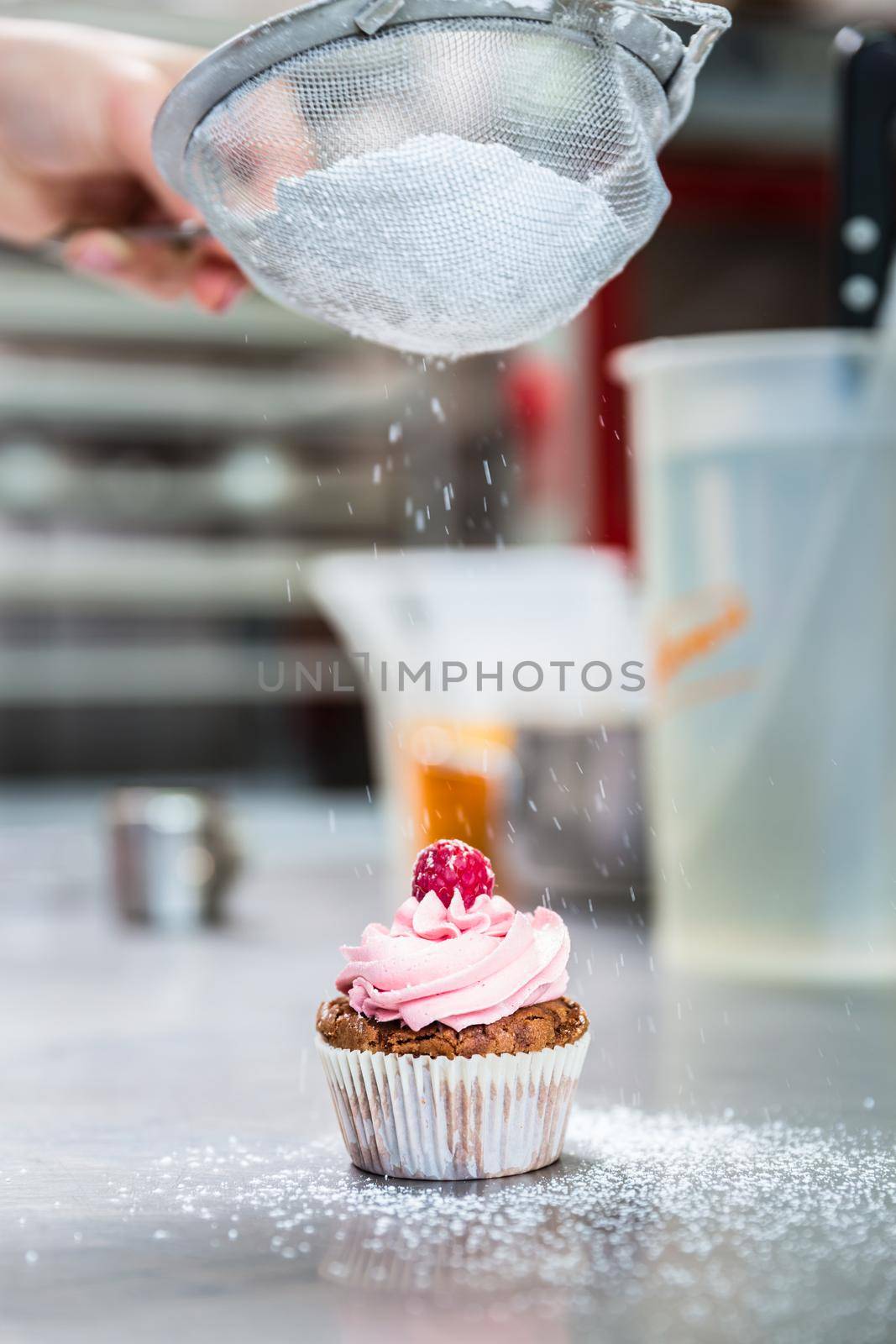 Woman in confectionary icing yummy cupcakes with sugar