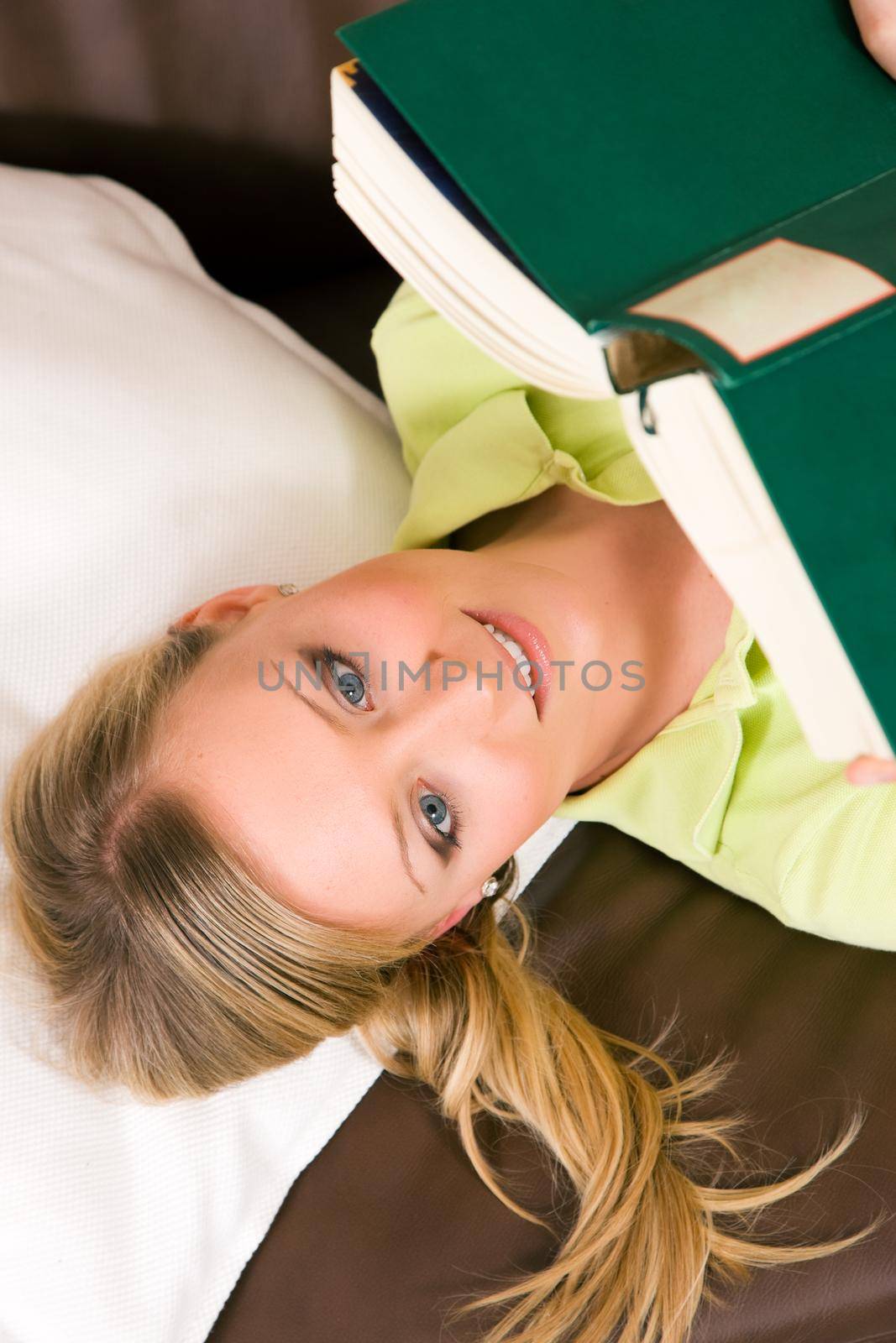 Woman having fun reading a book on the sofa