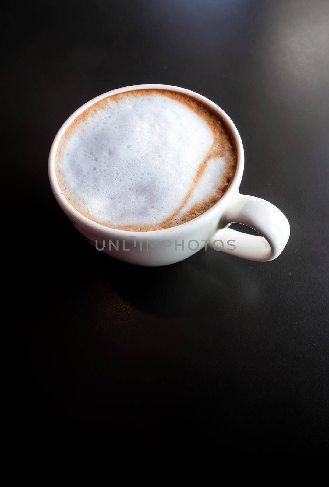 Hot milk coffee and soft froth in white ceramic cup