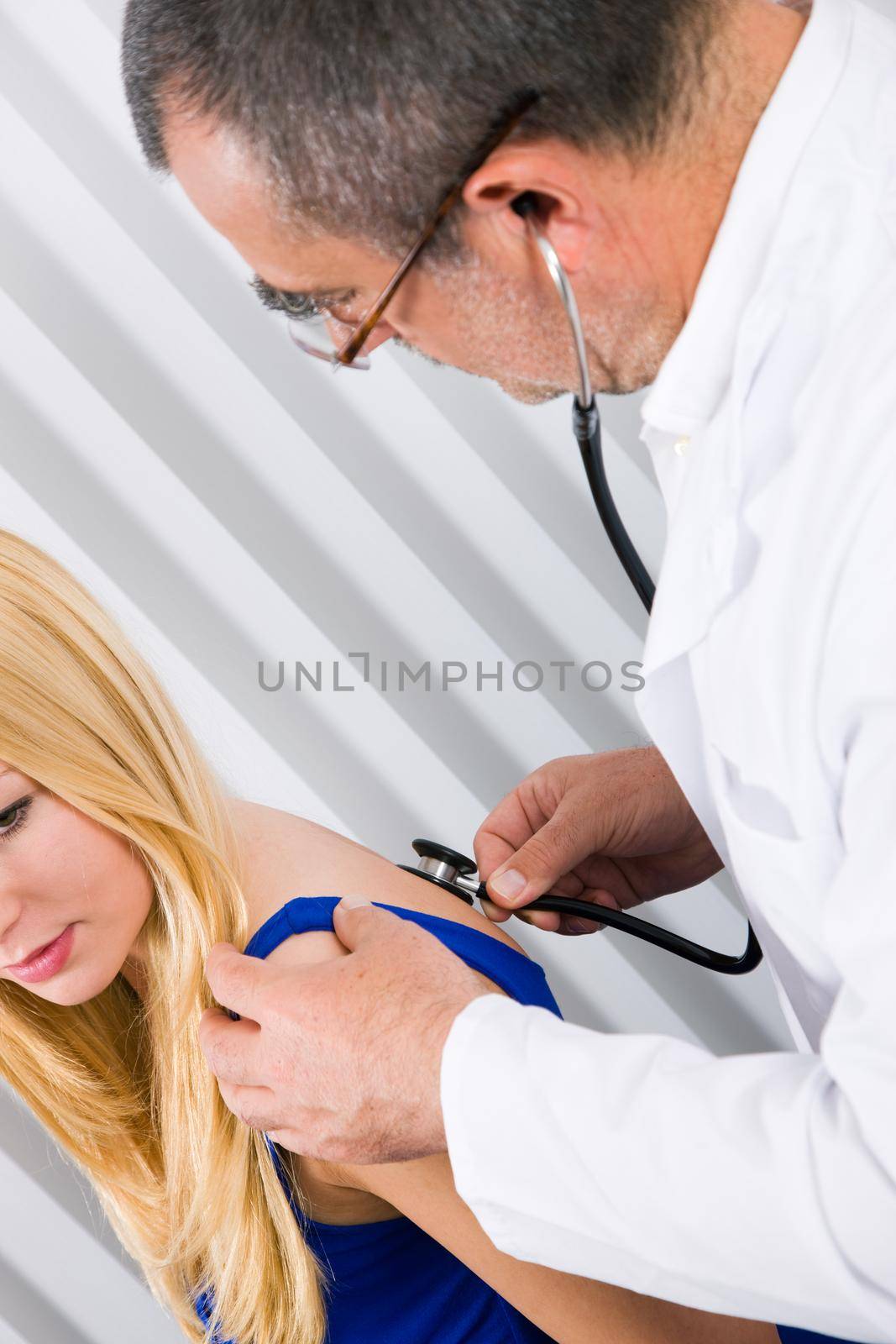 Doctor examining a female patient using a stethoscope