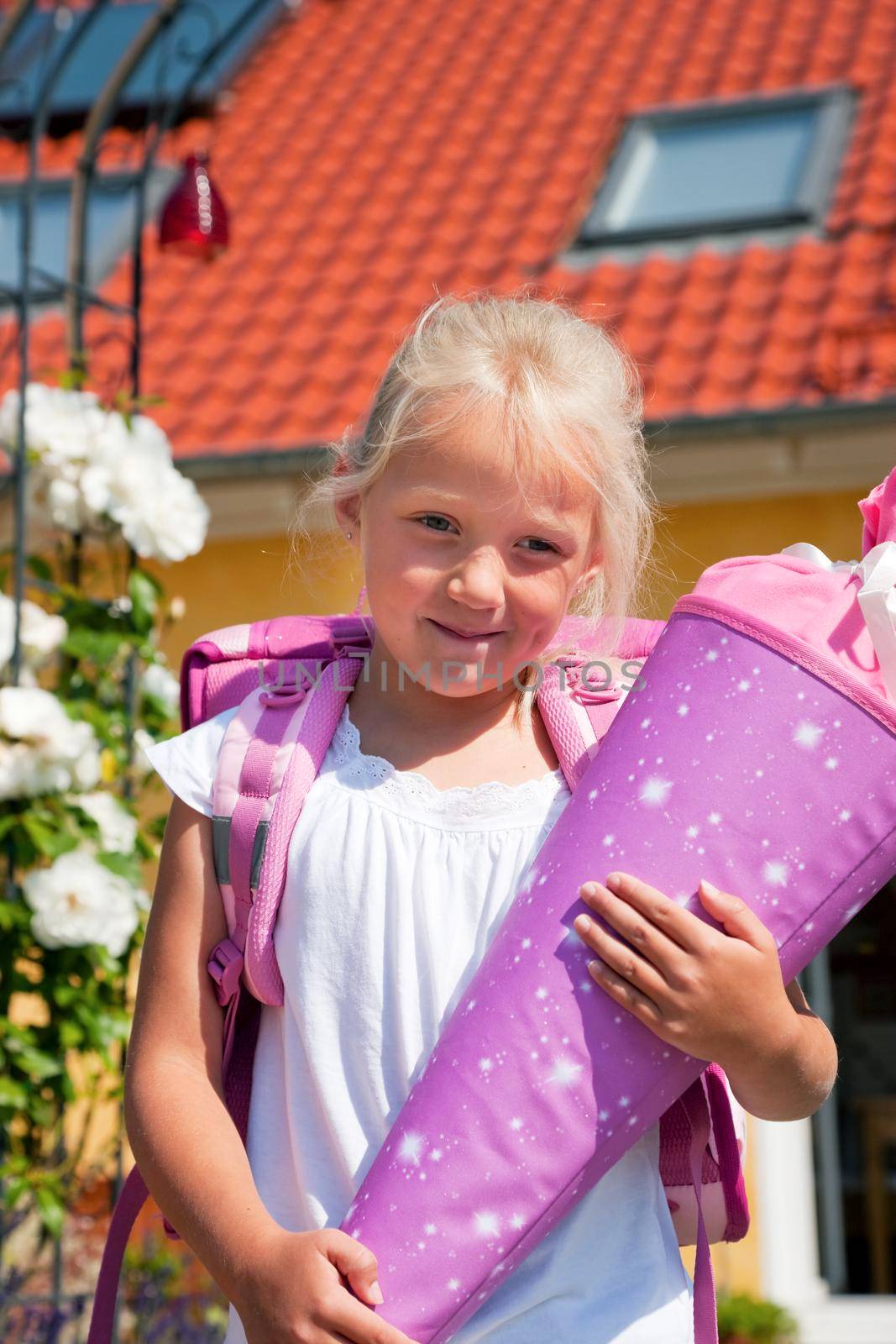 Proud kid having first day at school holding a traditional cone filled with sweet stuff