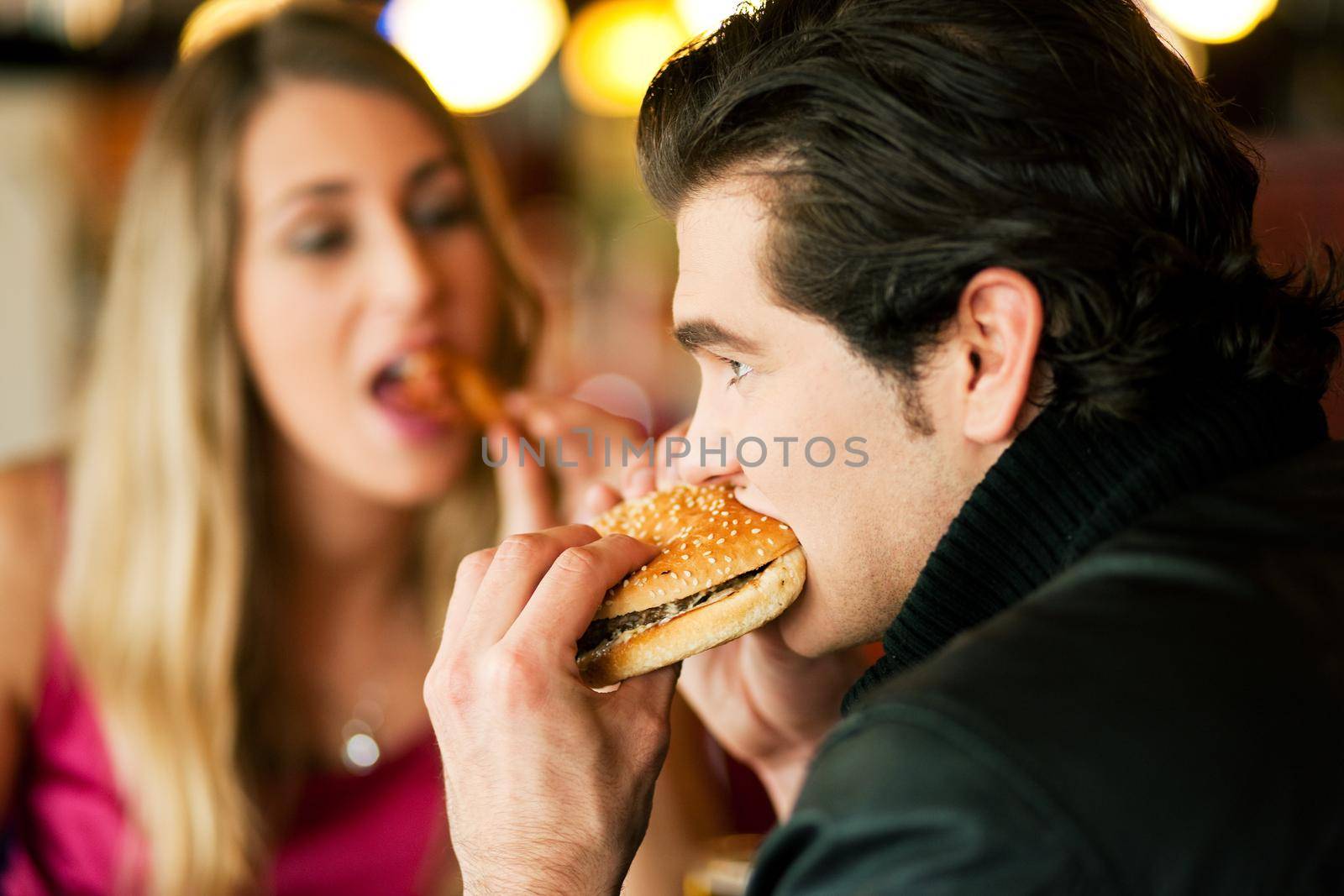 Couple in Restaurant eating fast food by Kzenon