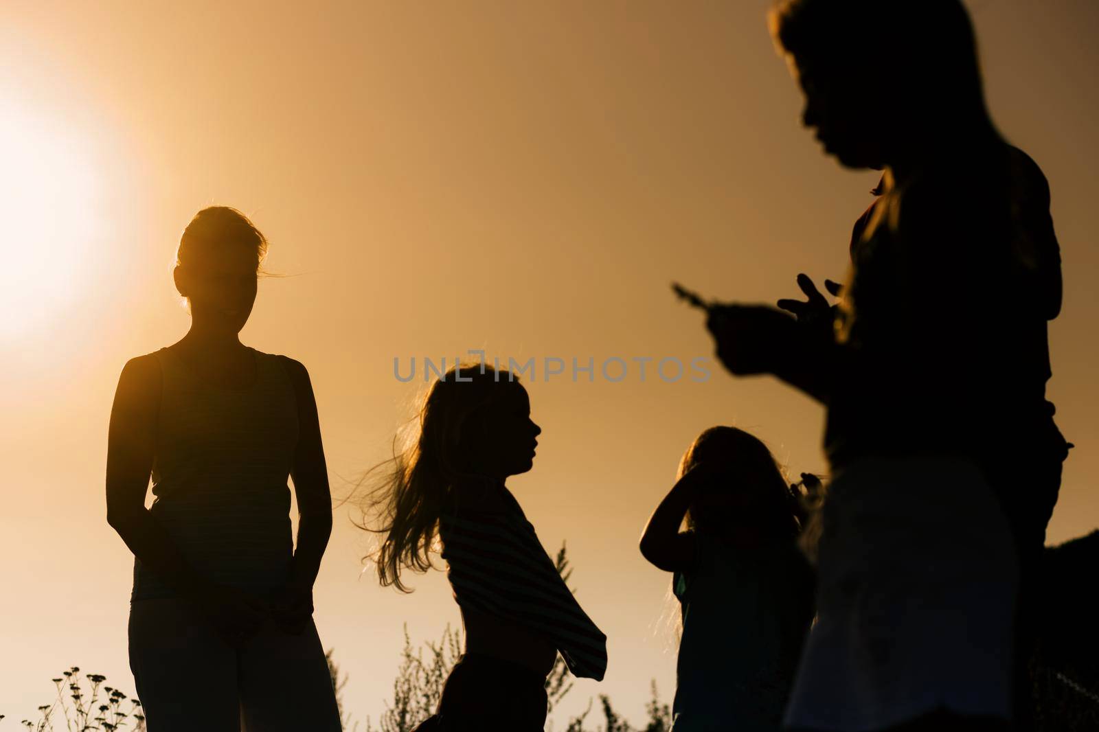 Family standing in strong back light leaving a silhouette and a very dreamy mood in the picture