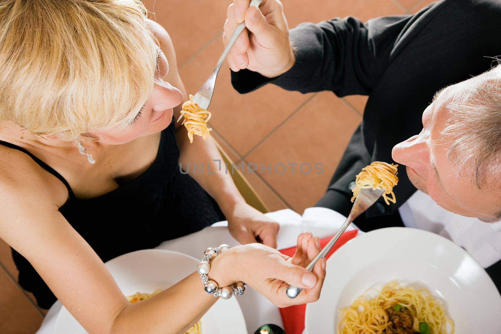 Couple eating pasta for dinner by Kzenon