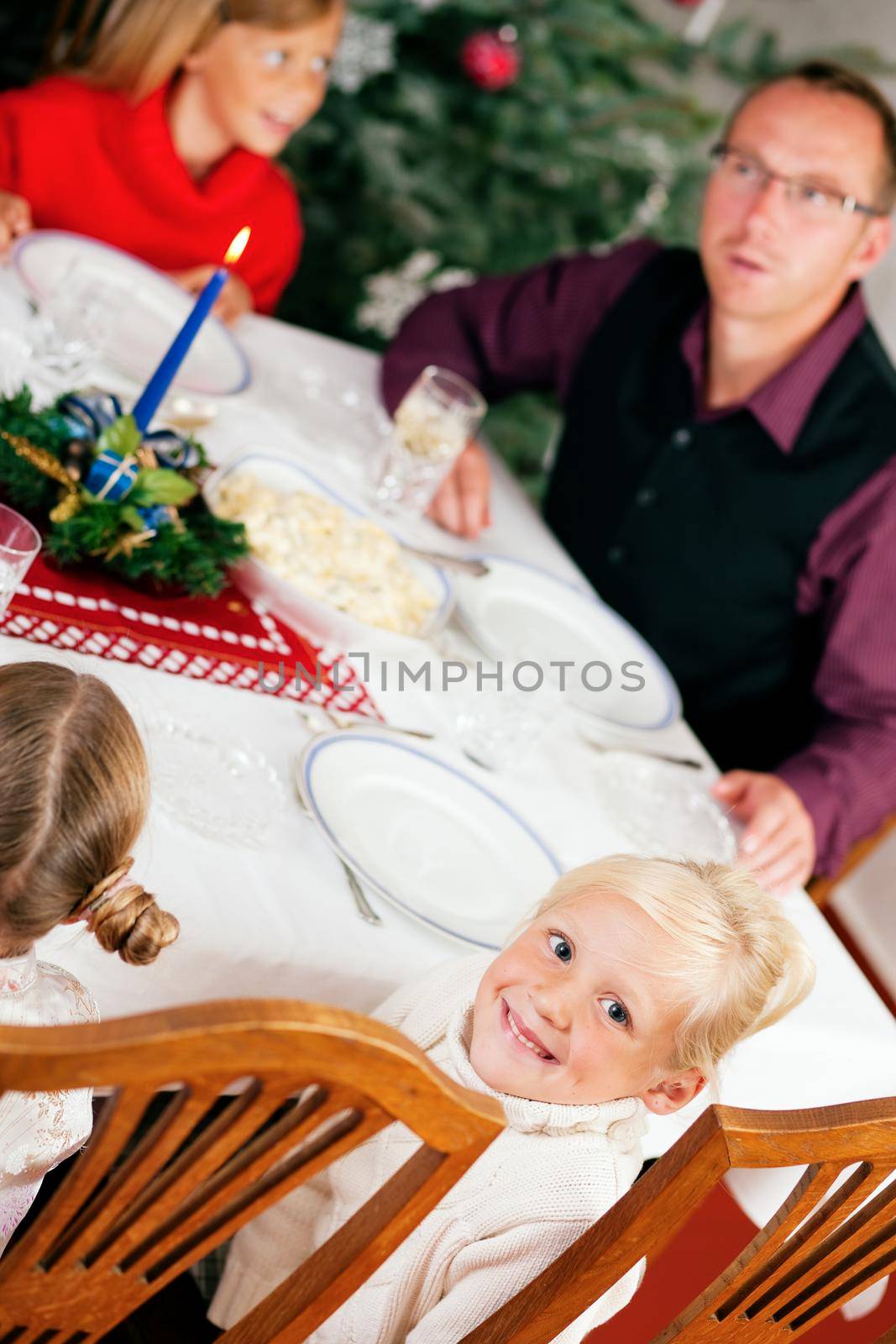 Family eating a traditional Christmas Dinner in front of the Christmas tree