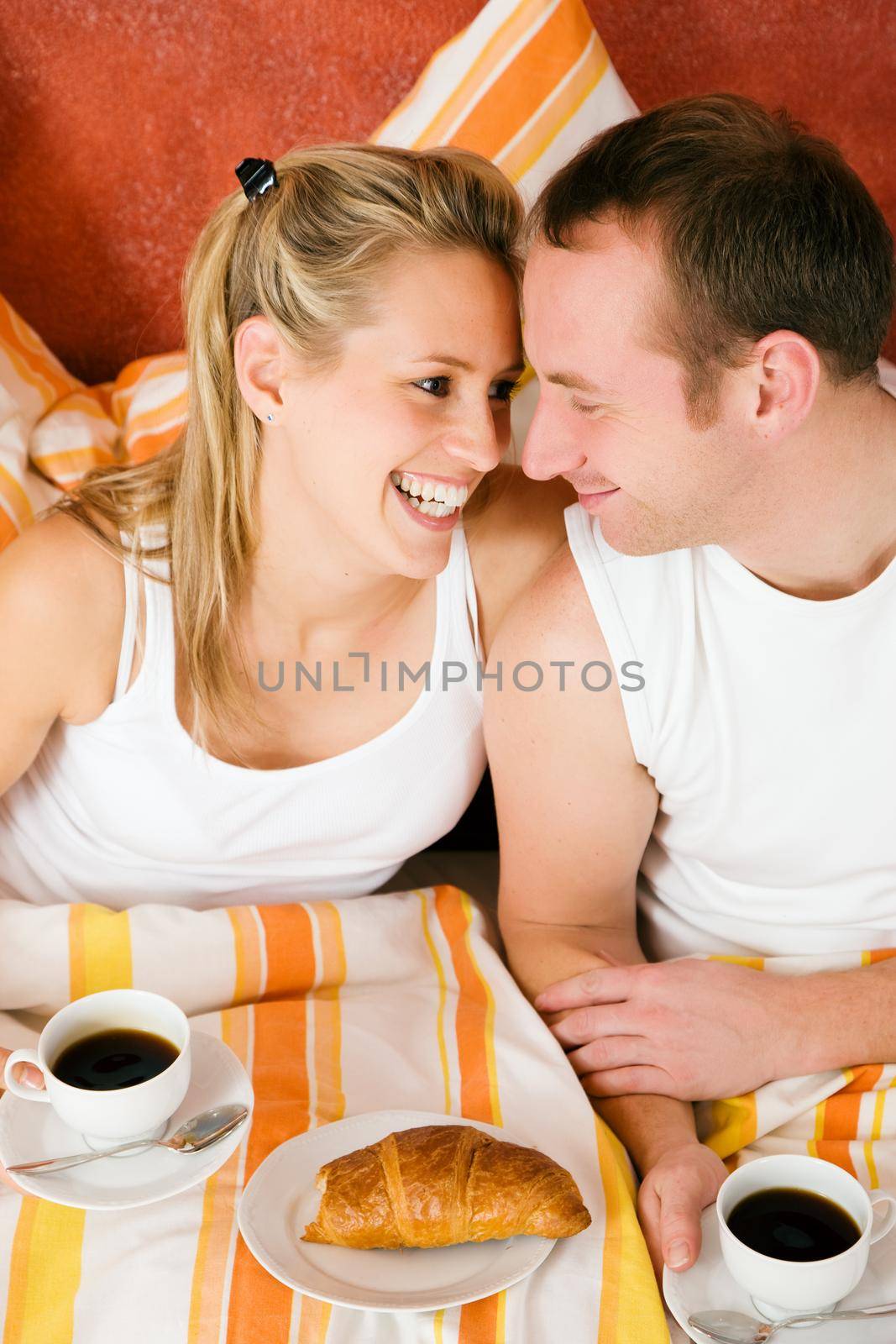 Couple having breakfast in bed in the morning
