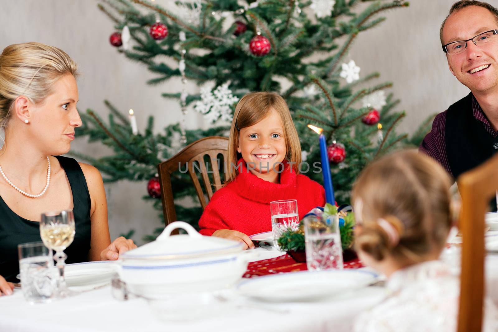 Family eating a traditional Christmas Dinner in front of the Christmas tree