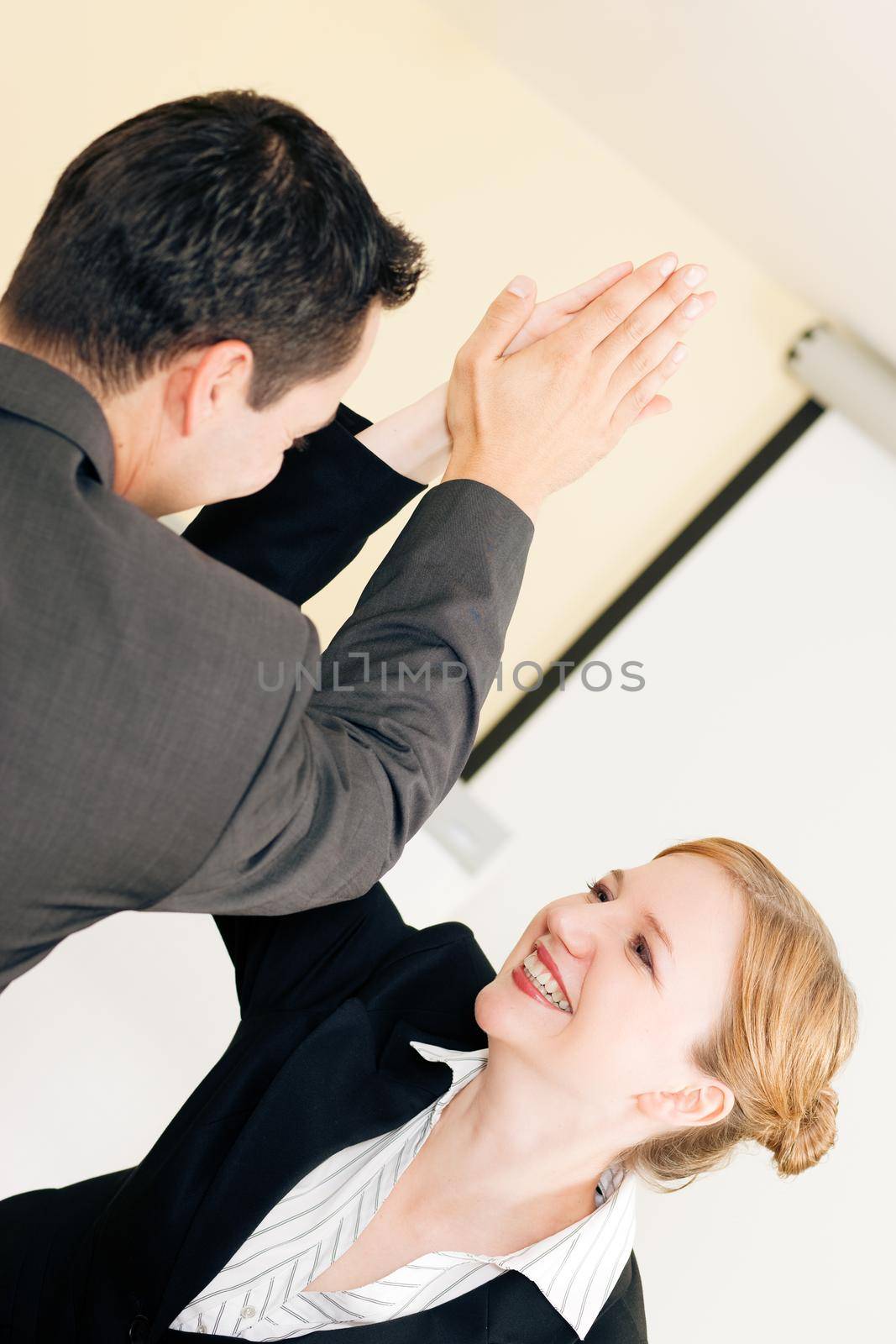 Two people in Business giving each other a high five for a successful transaction