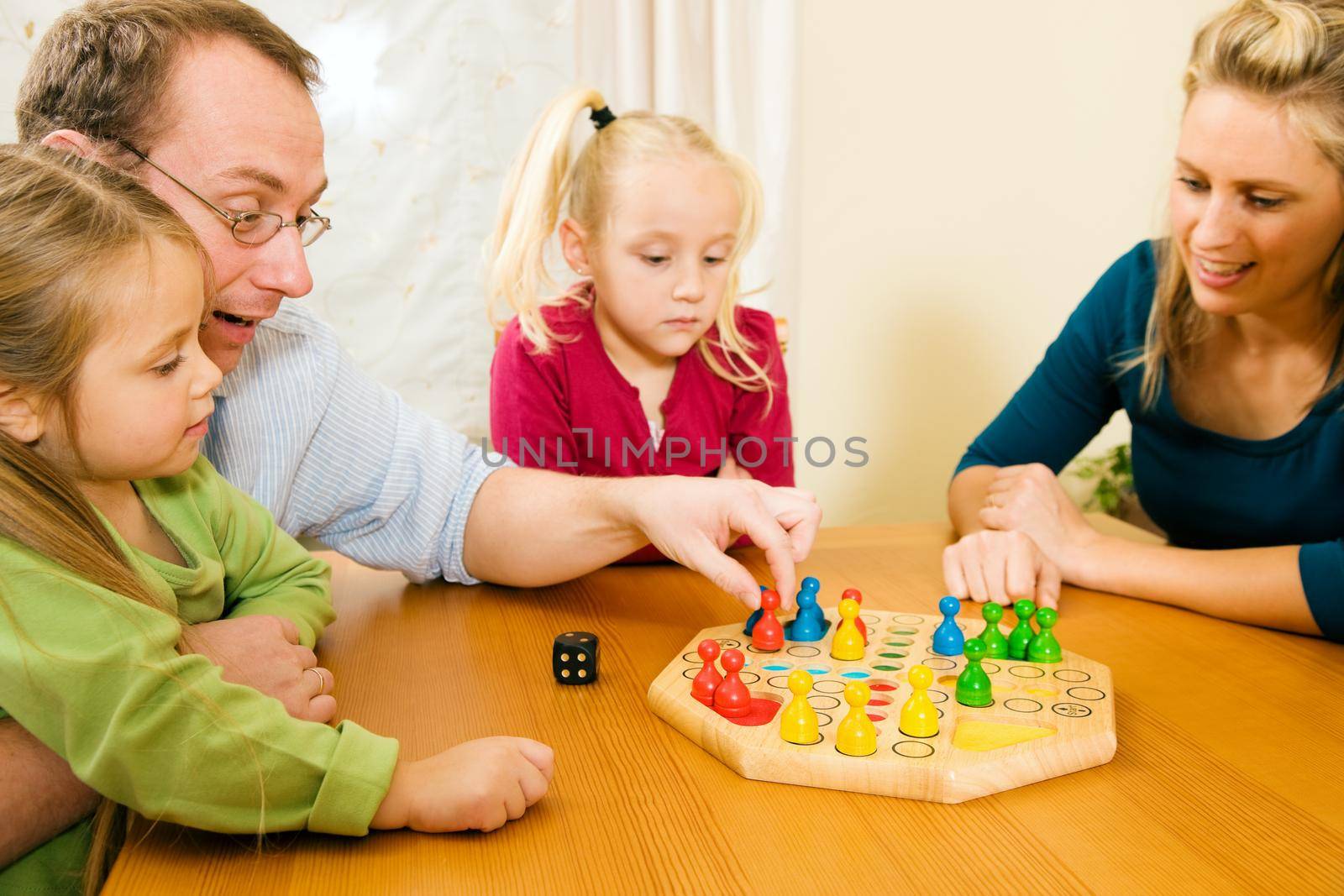 Family is playing ludo together by Kzenon