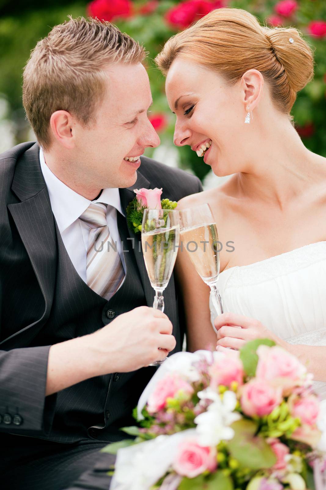 Wedding couple clinking champagne glasses by Kzenon