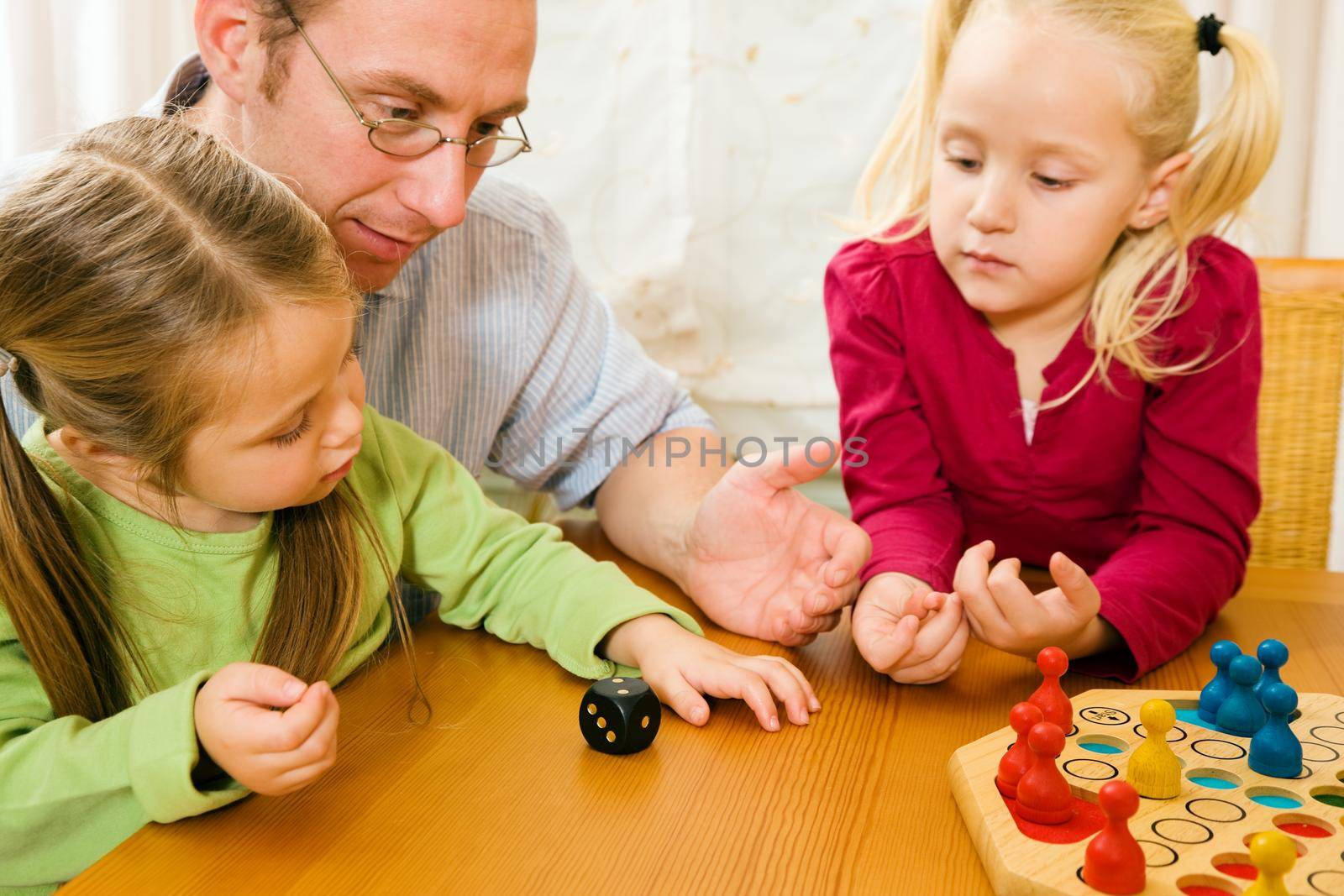 Family is playing ludo together by Kzenon