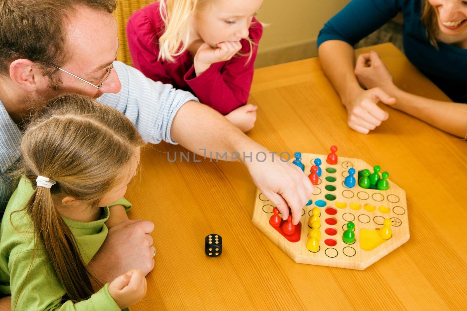 Family playing a board game together having a lot of fun