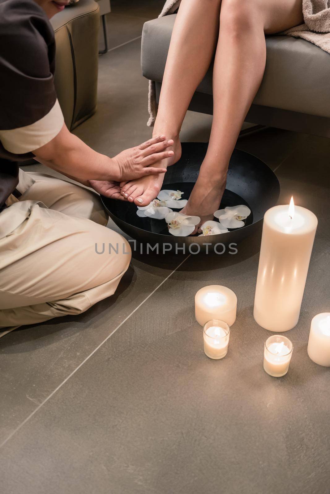 Hands of an Asian therapist during foot washing treatment by Kzenon