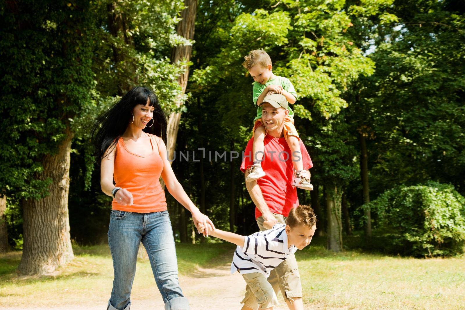 Family with two kids having a walk in the park (focus is on the boy in front!)