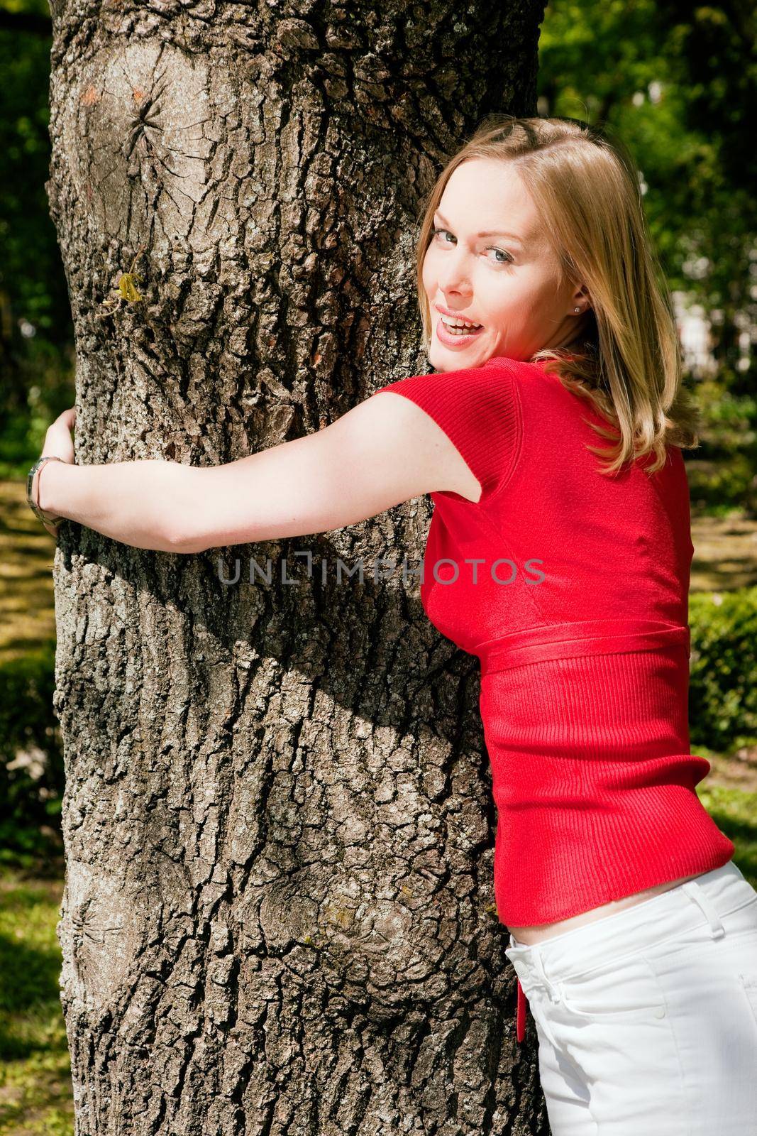 Girl cuddling a tree and dreaming - a metaphor for environmentalism