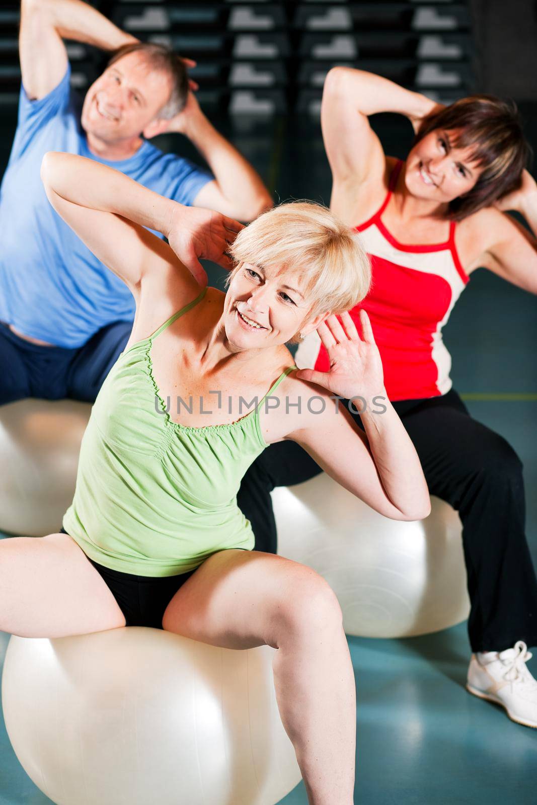 People in gym on exercise ball by Kzenon