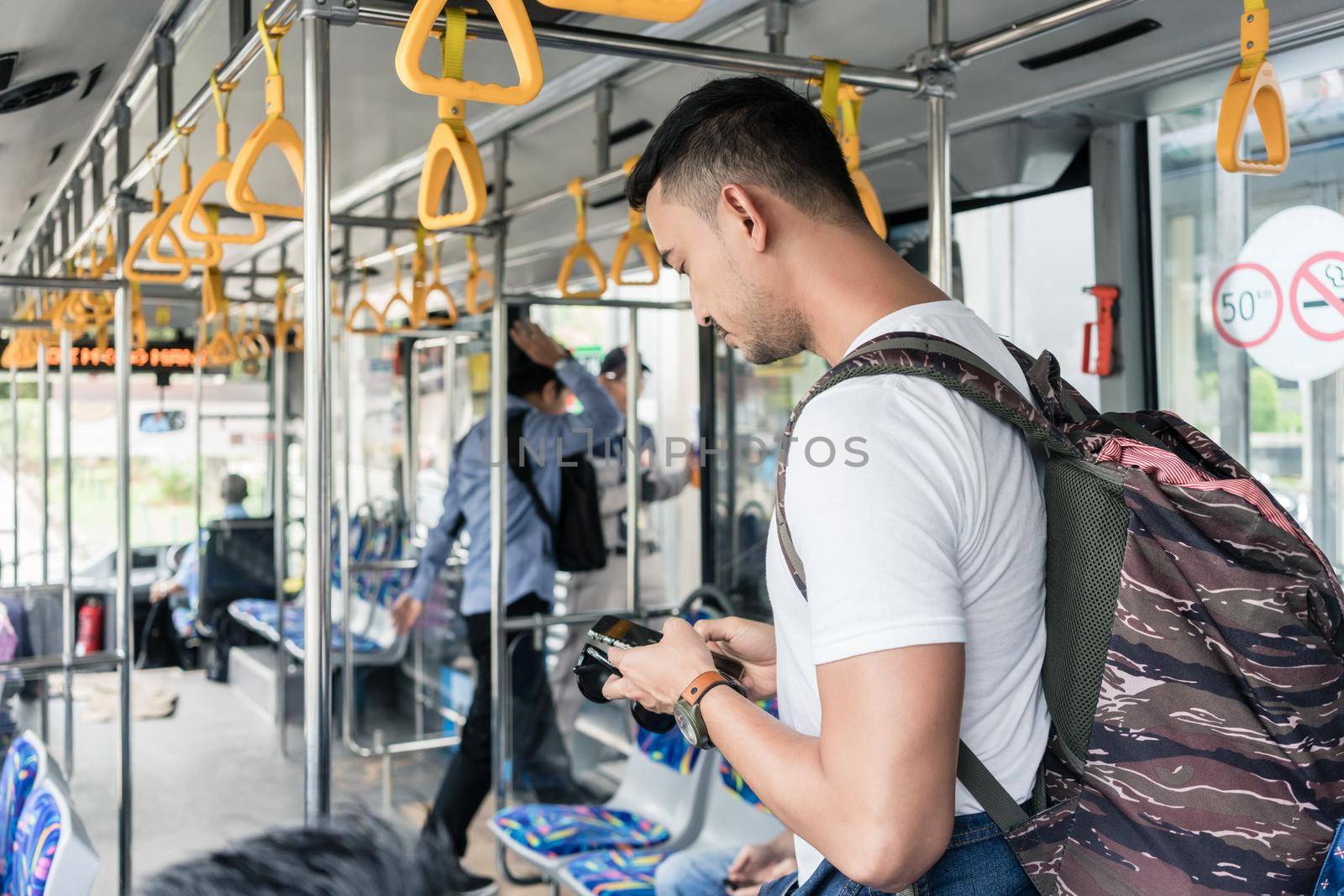 Young male tourist using the mobile phone by Kzenon