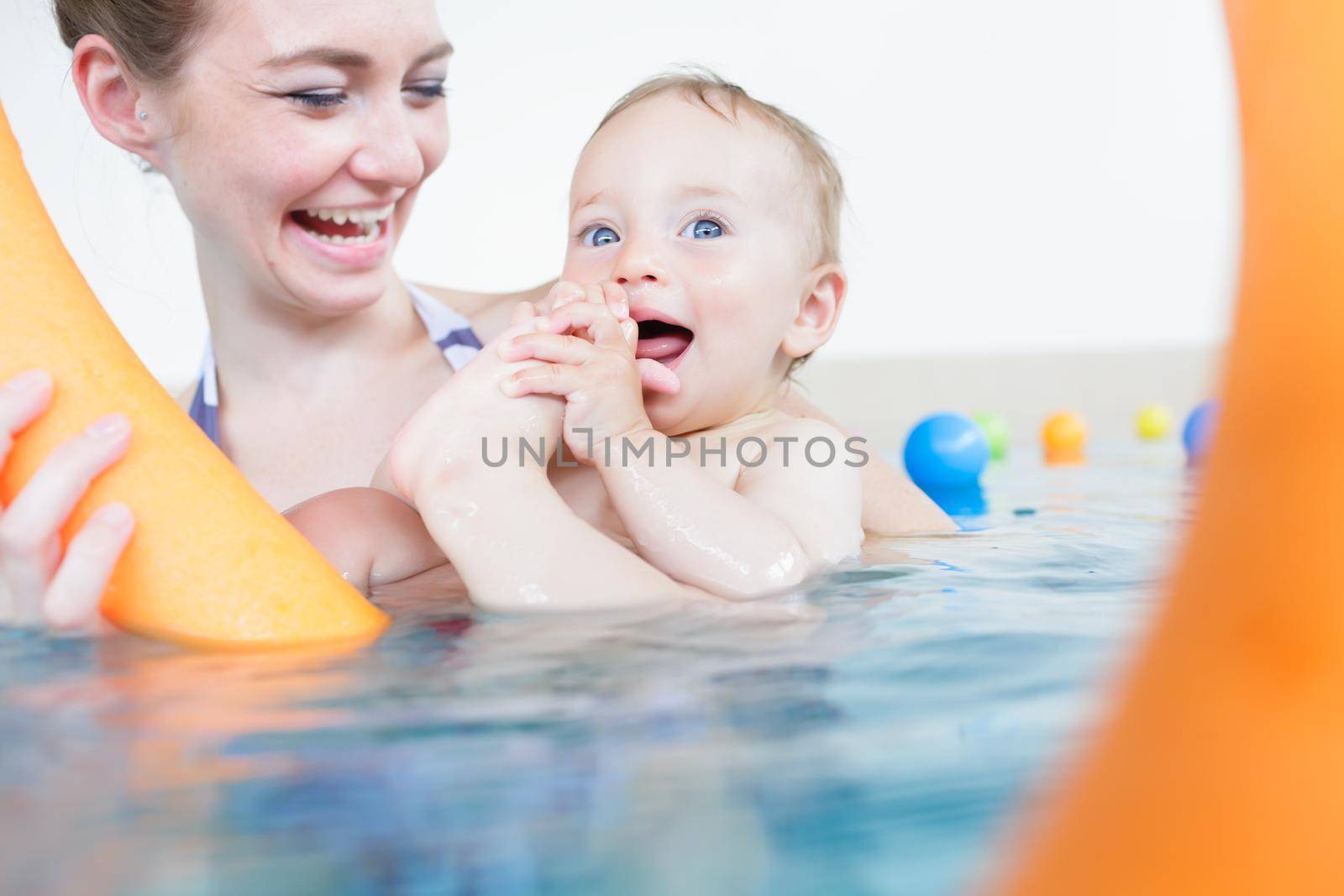 Mothers being happy about their babies playing with each other in pool by Kzenon