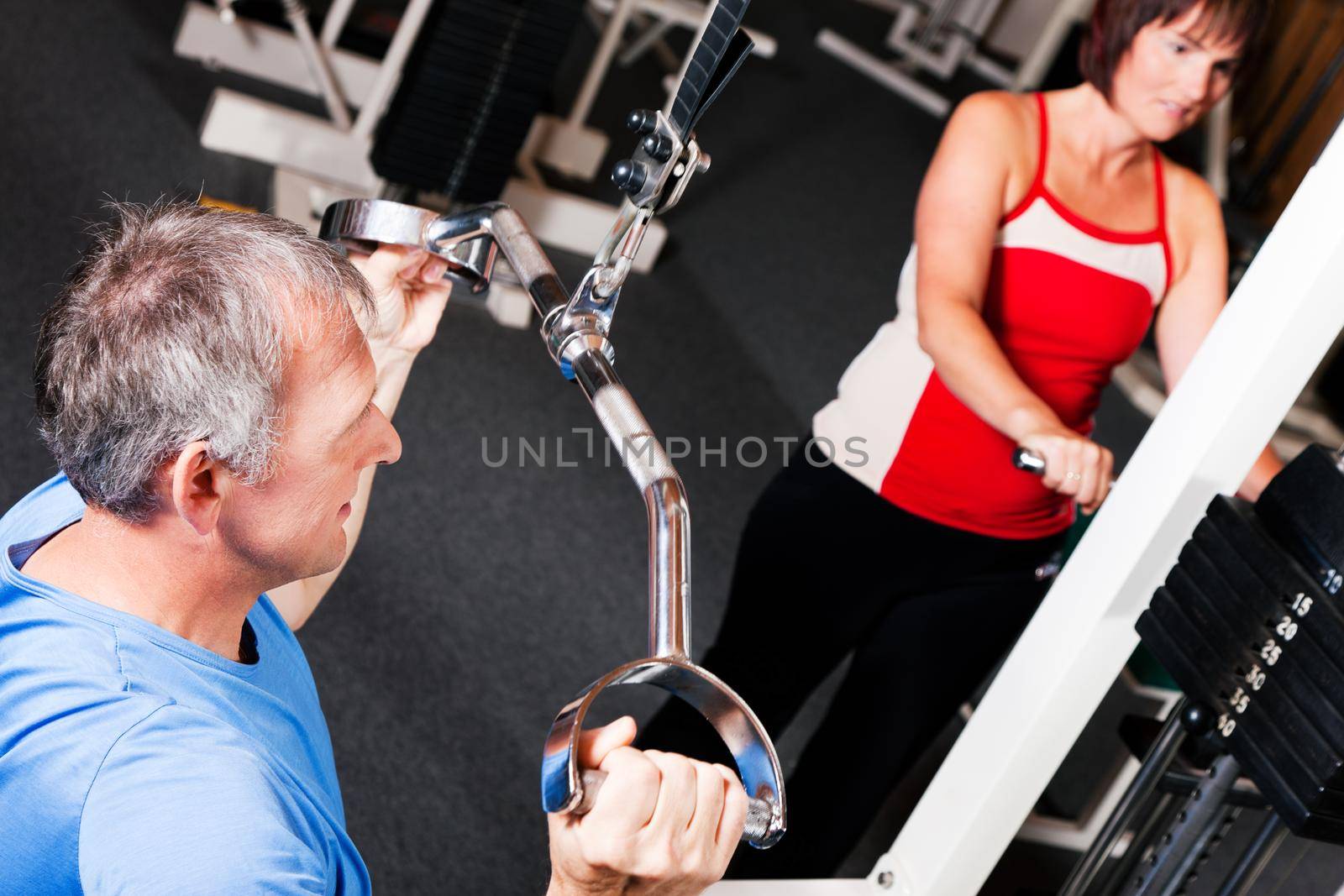 senior people exercising in gym by Kzenon