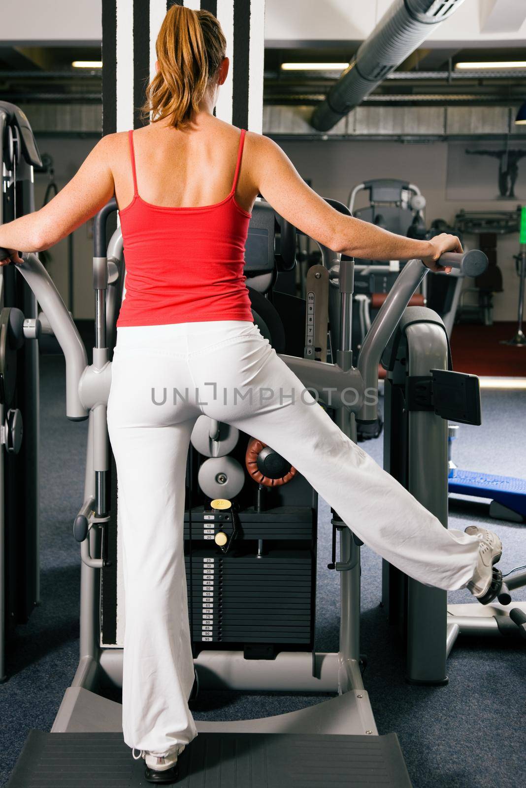 Woman working out in gym by Kzenon