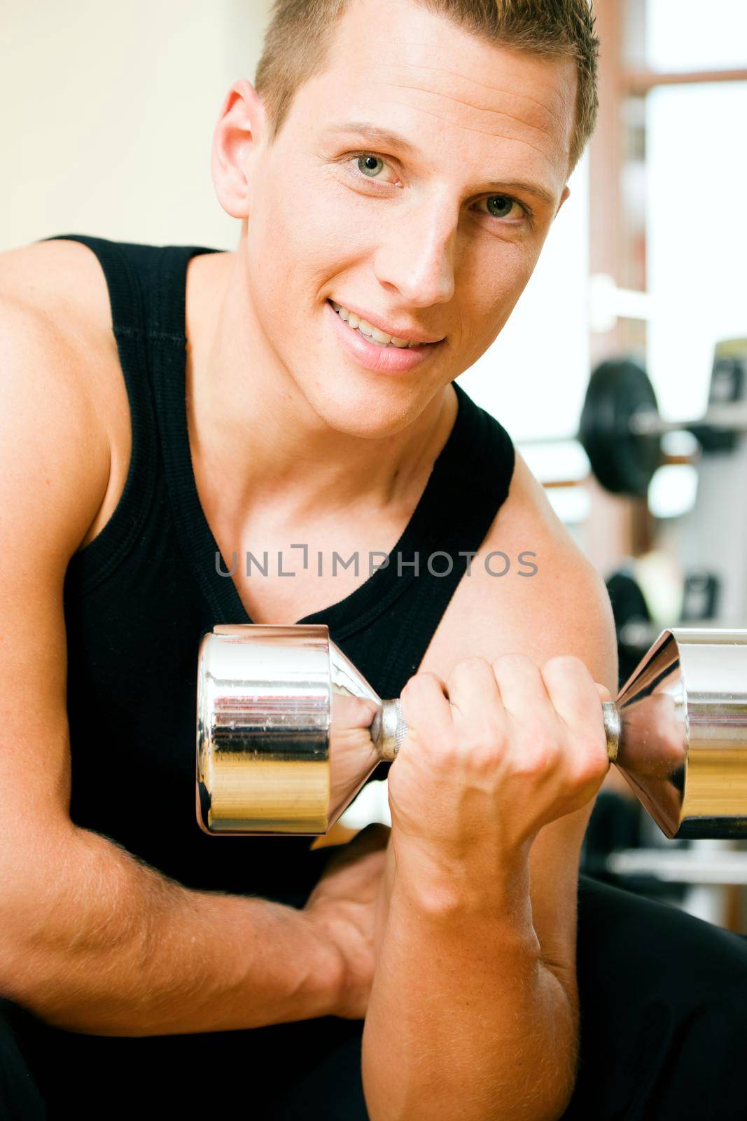 Man having a workout with dumbbell in the gym