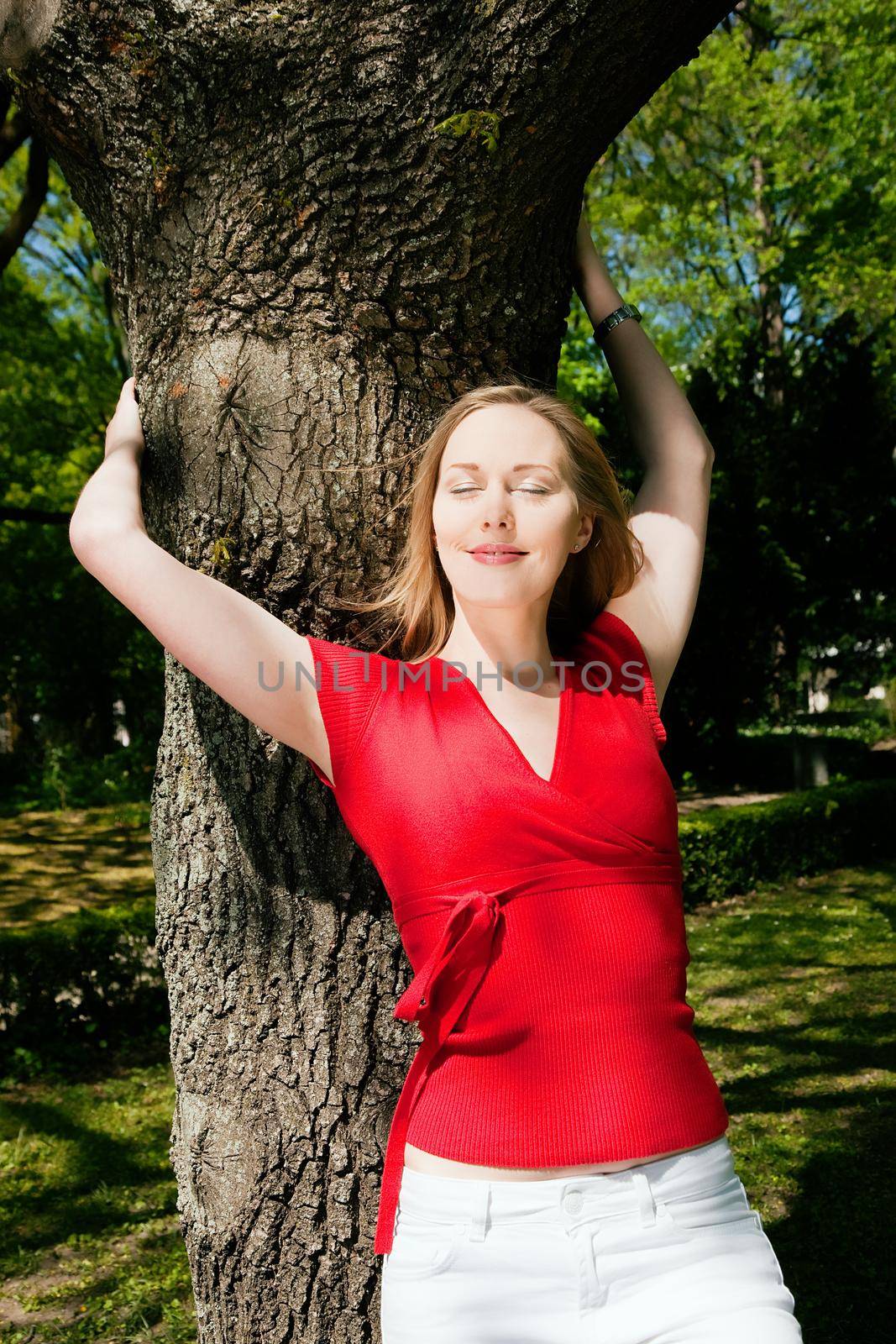 Girl dreaming on a tree in a park by Kzenon