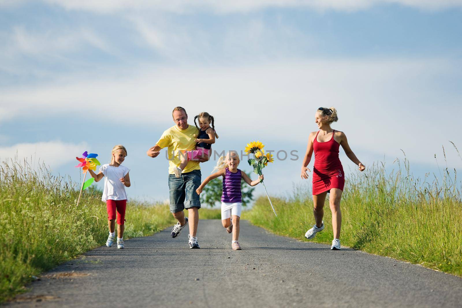 Family with three kids running down a hill