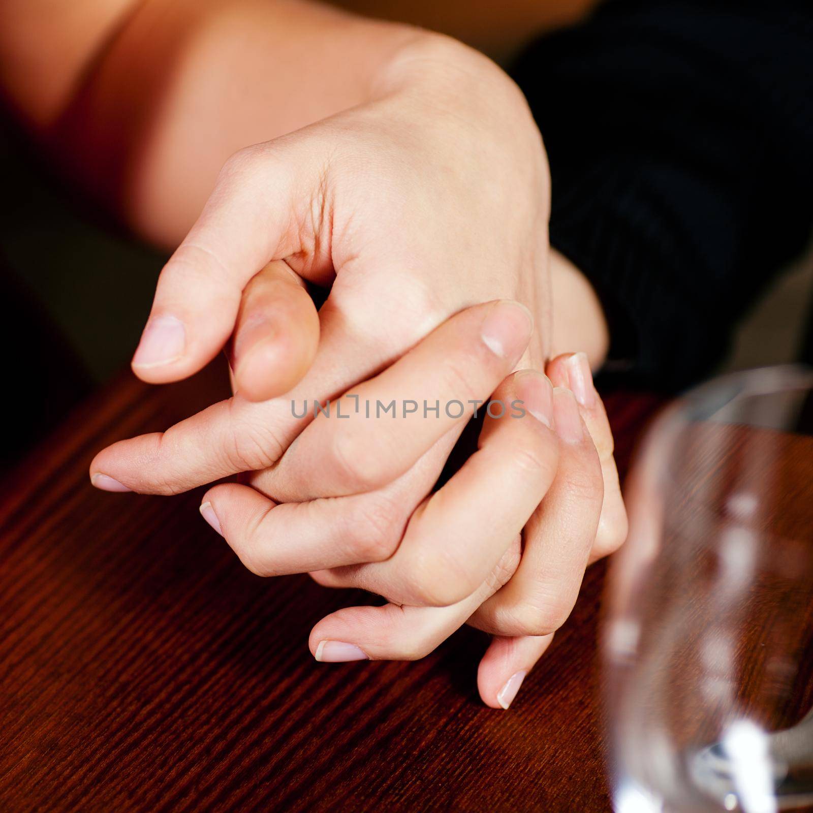 Couple holding hands on a table by Kzenon