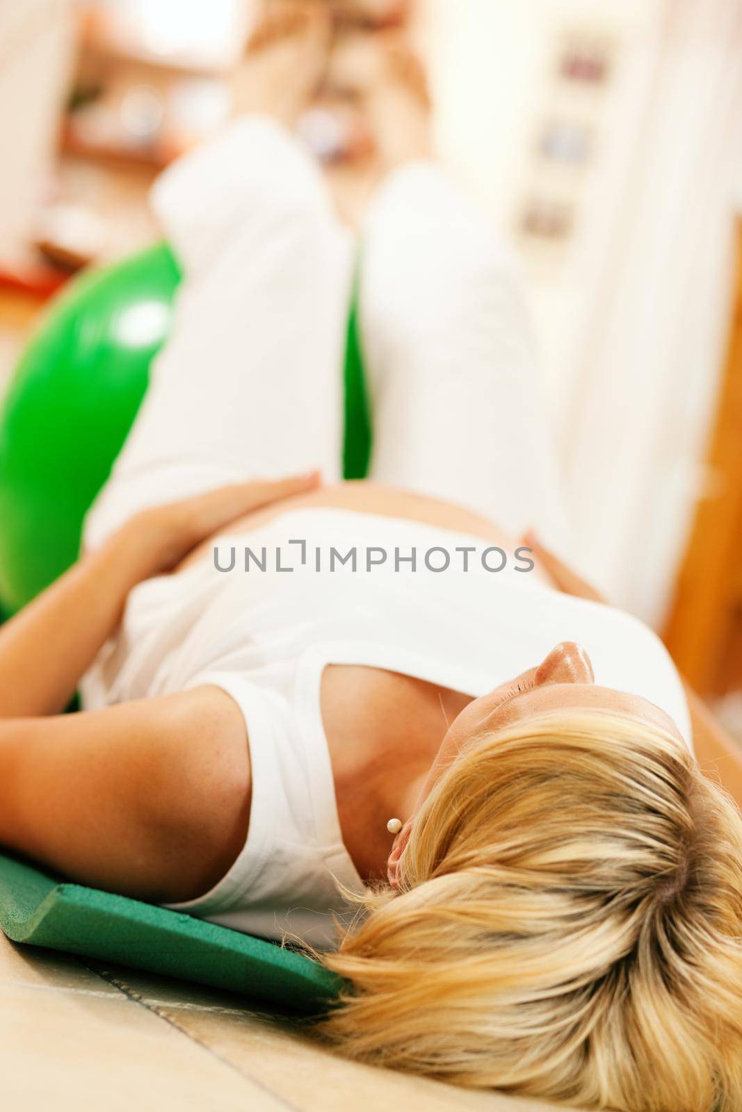 Pregnant woman doing pregnancy gymnastics by Kzenon