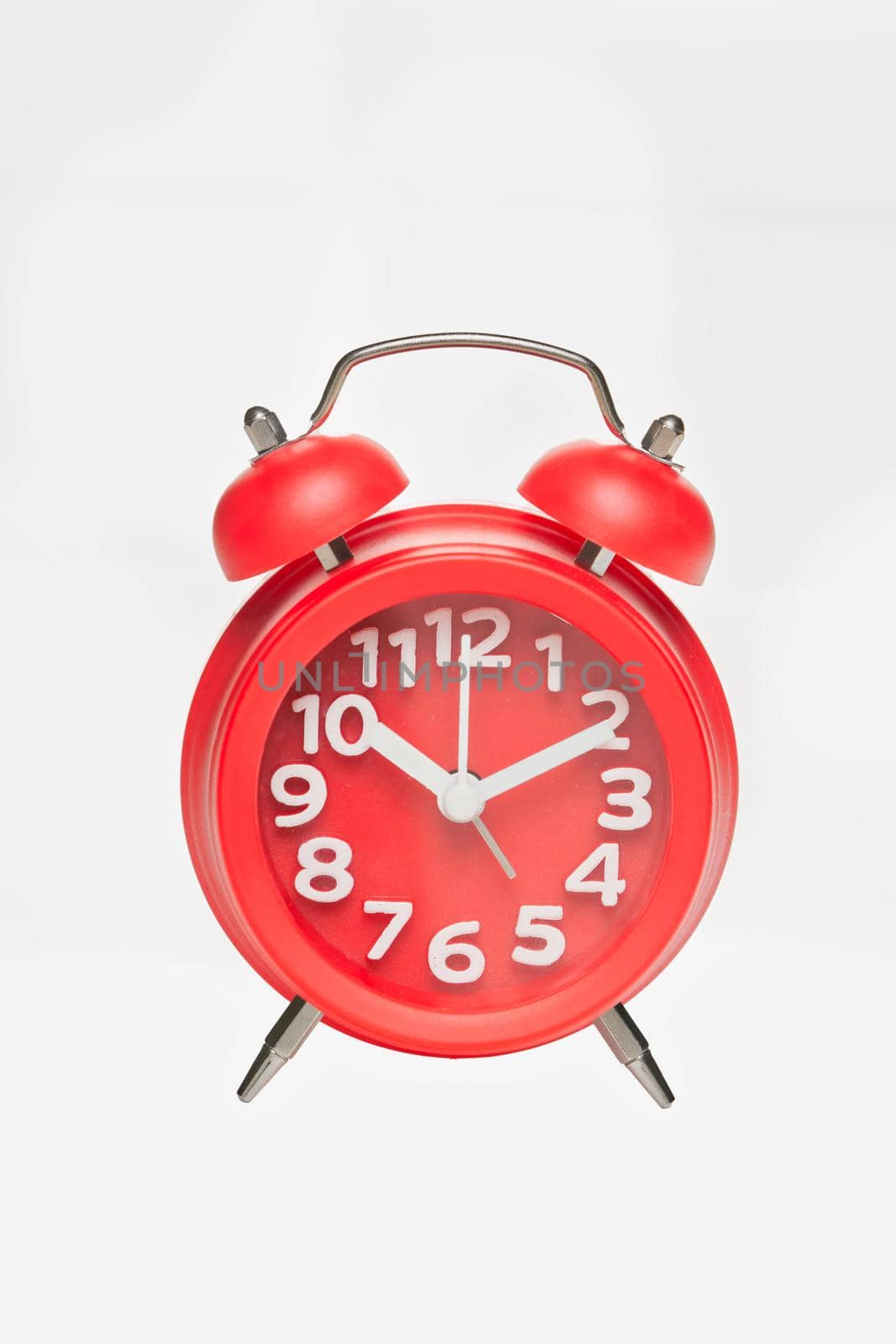 Red retro alarm clock with digital dial and hour hands on white background. Close up