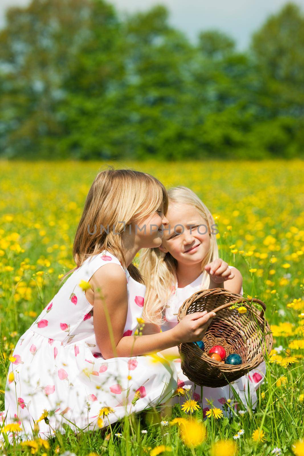 Children on Easter egg hunt with eggs by Kzenon