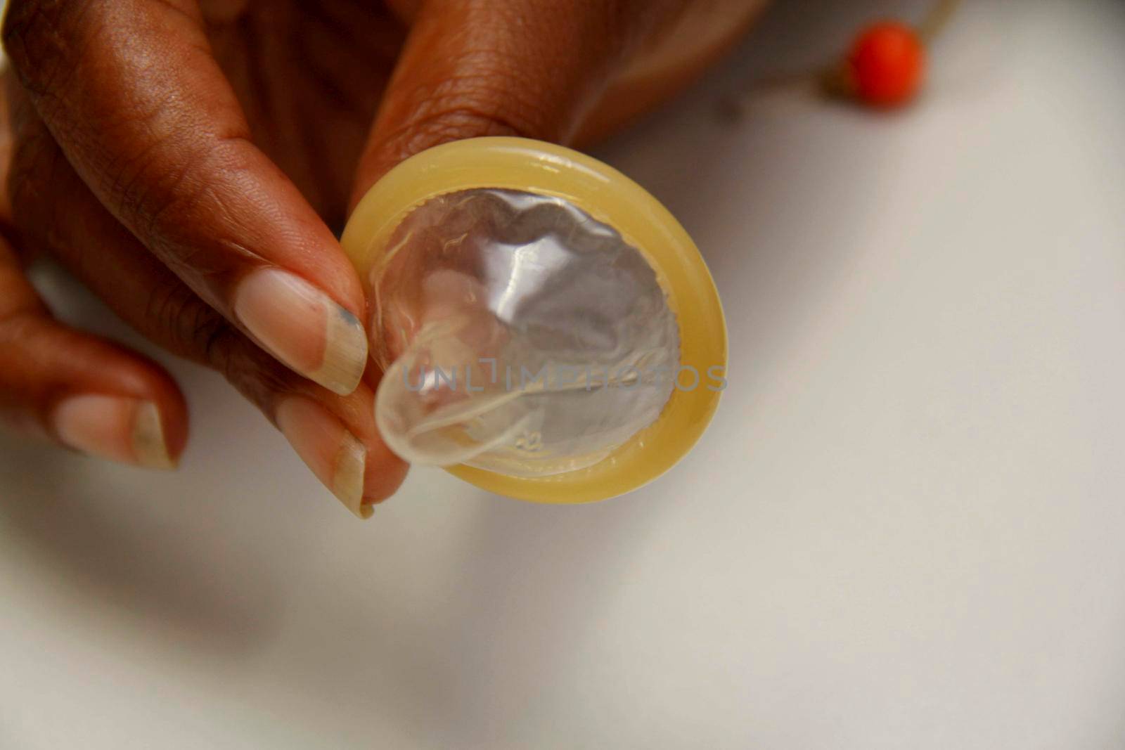 salvador, bahia / brazil - february 6, 2013: hand holds male condom, contraceptive method and also used to control sexually transmitted diseases.
