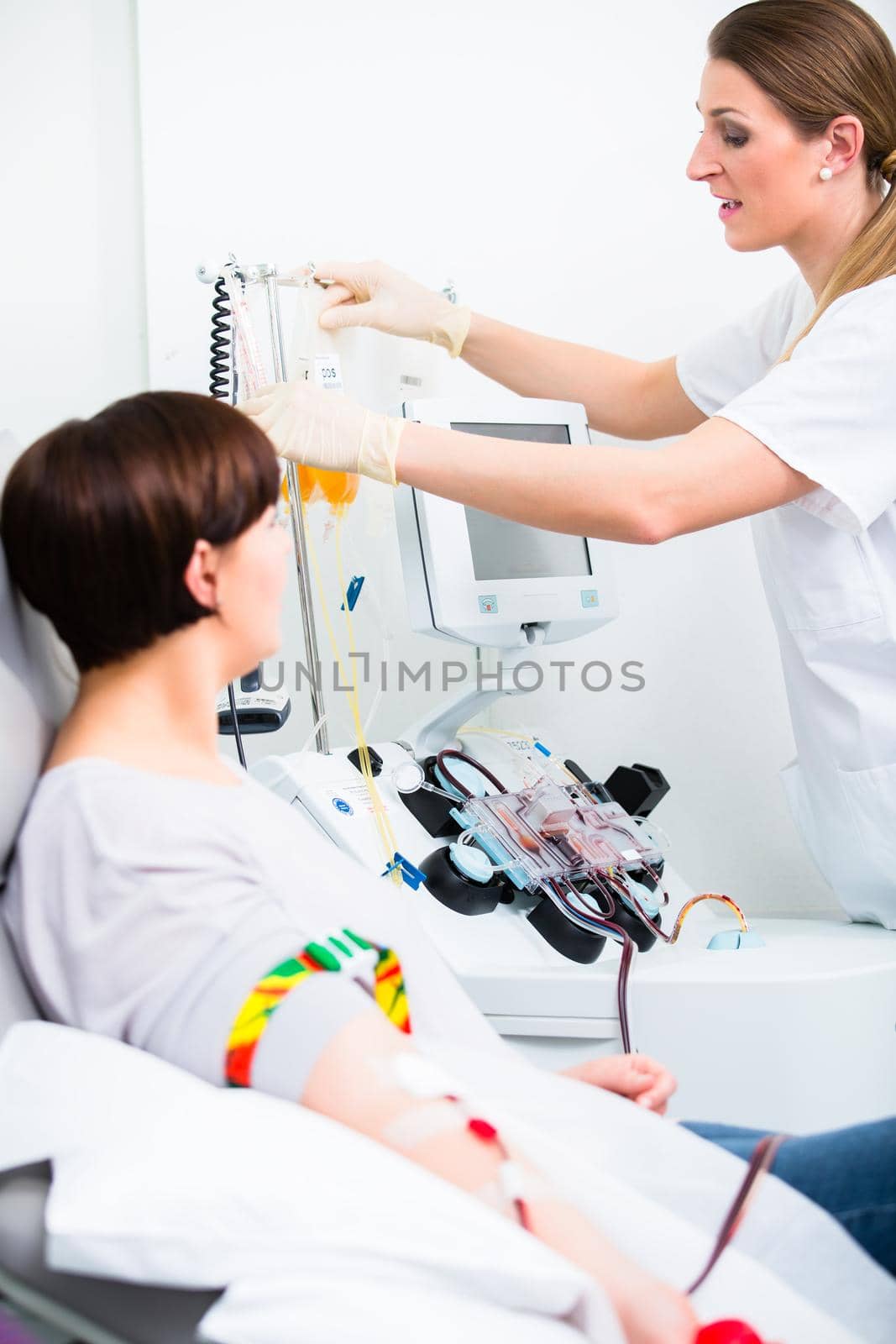 Cheerful doctor in intensive medical care checking results of woman patient