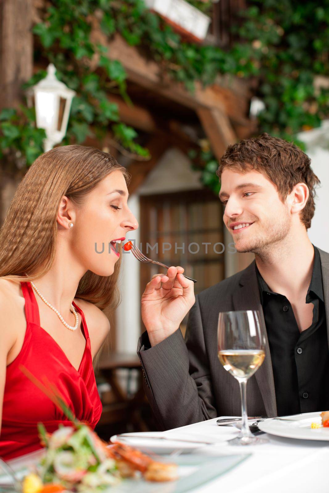 Couple on romantic date at a restaurant with food and wine