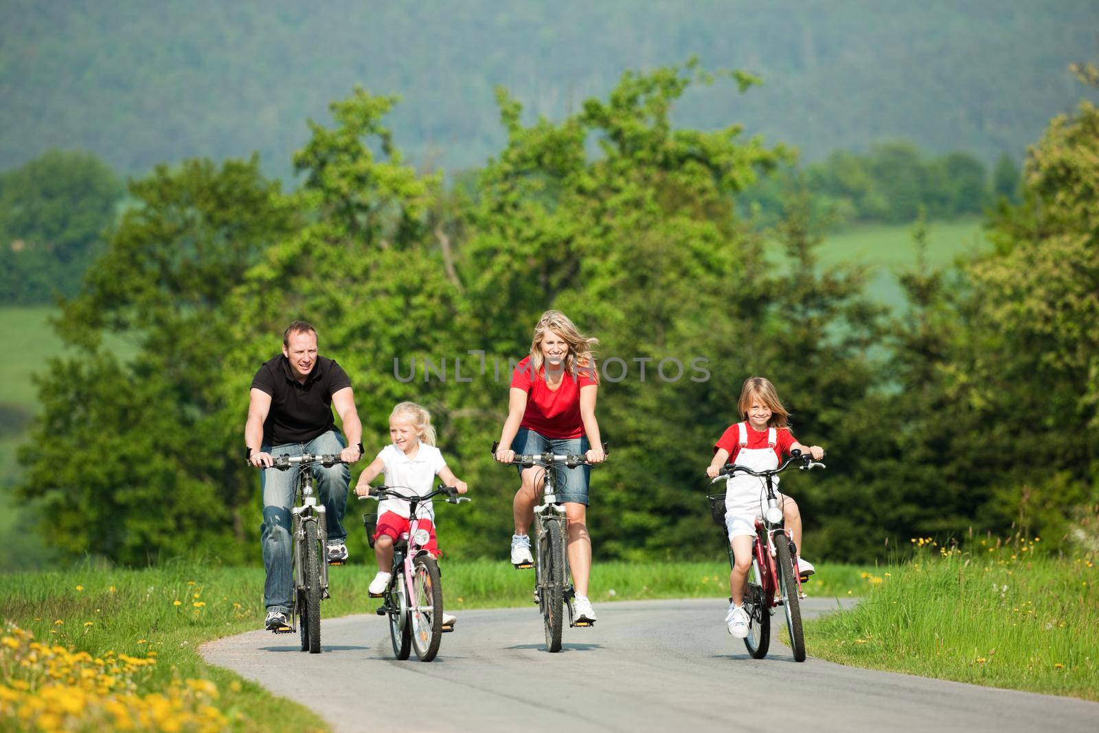 Family with children having a weekend excursion on their bikes on a summer day