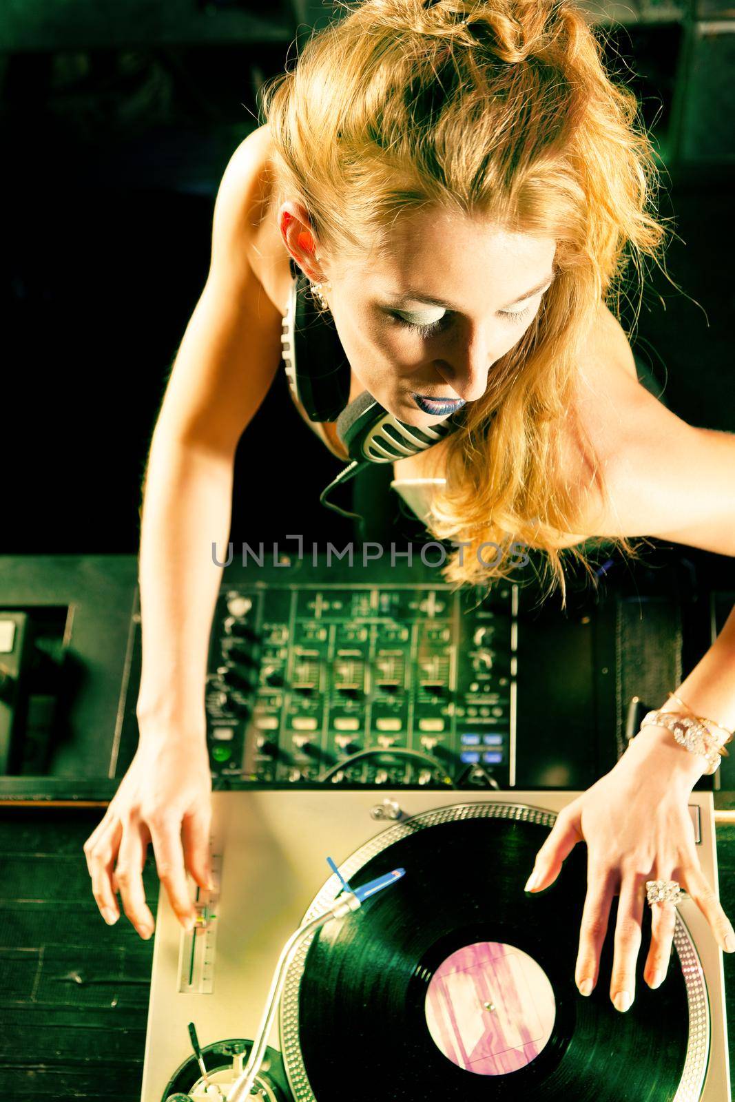 Female DJ at the turntable in Club by Kzenon