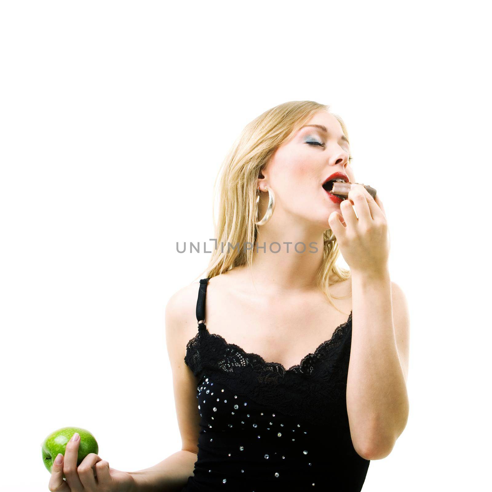 Food and healthy nutrition - Blond girl enjoying a chocolate bar and ignoring an apple