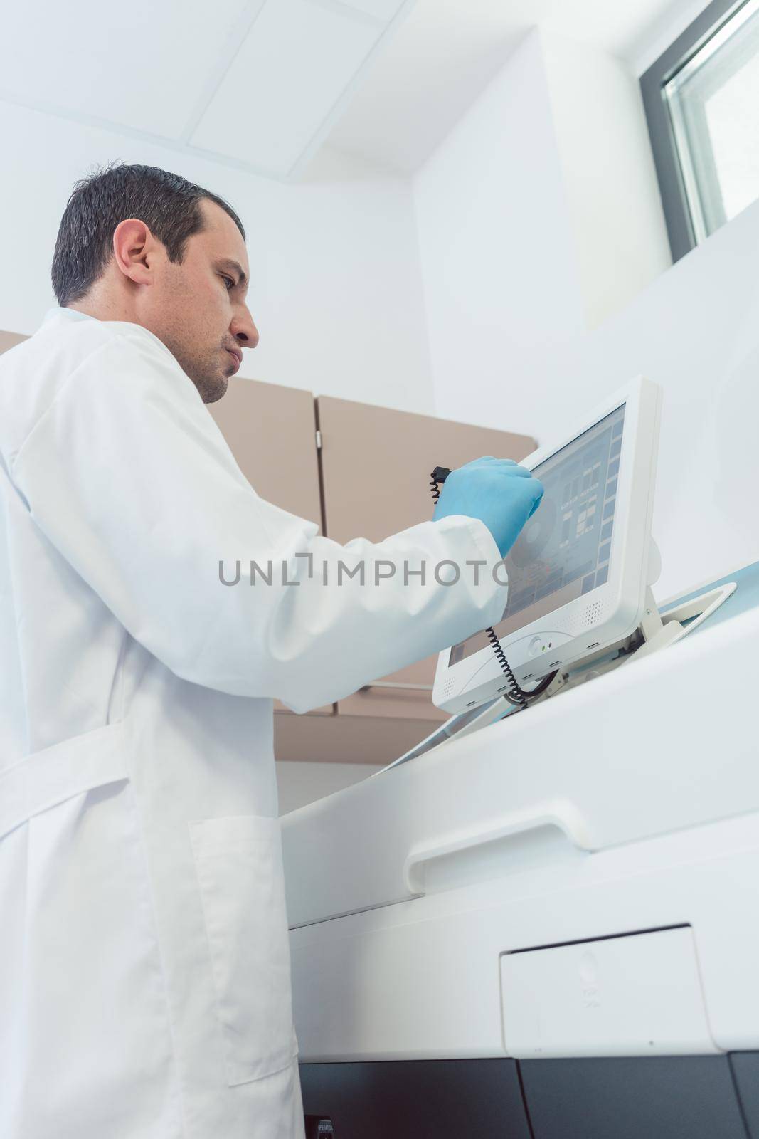 Doctor preparing a blood count in the laboratory programming the machine