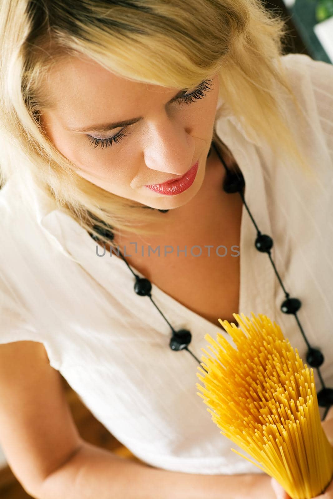 A woman with uncooked spaghetti (going to prepare them presumably)