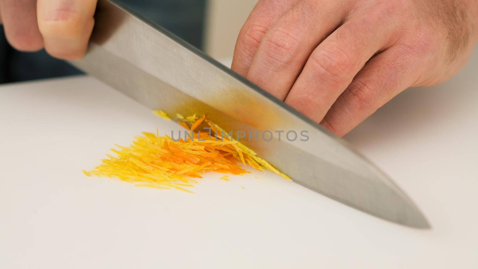 Man cutting or chopping orange and citron zests with a knife