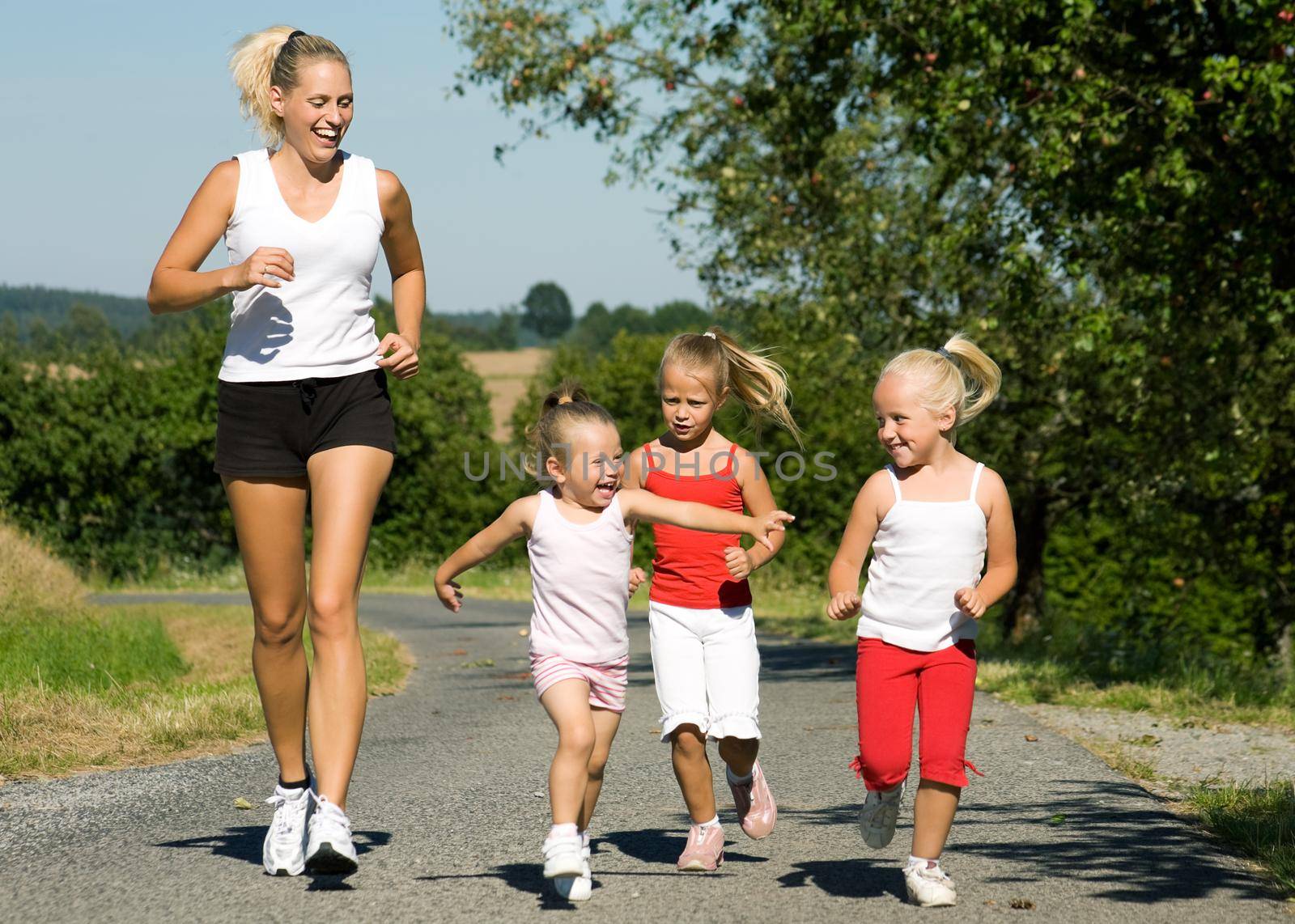 A young mother jogging with her three little daughters