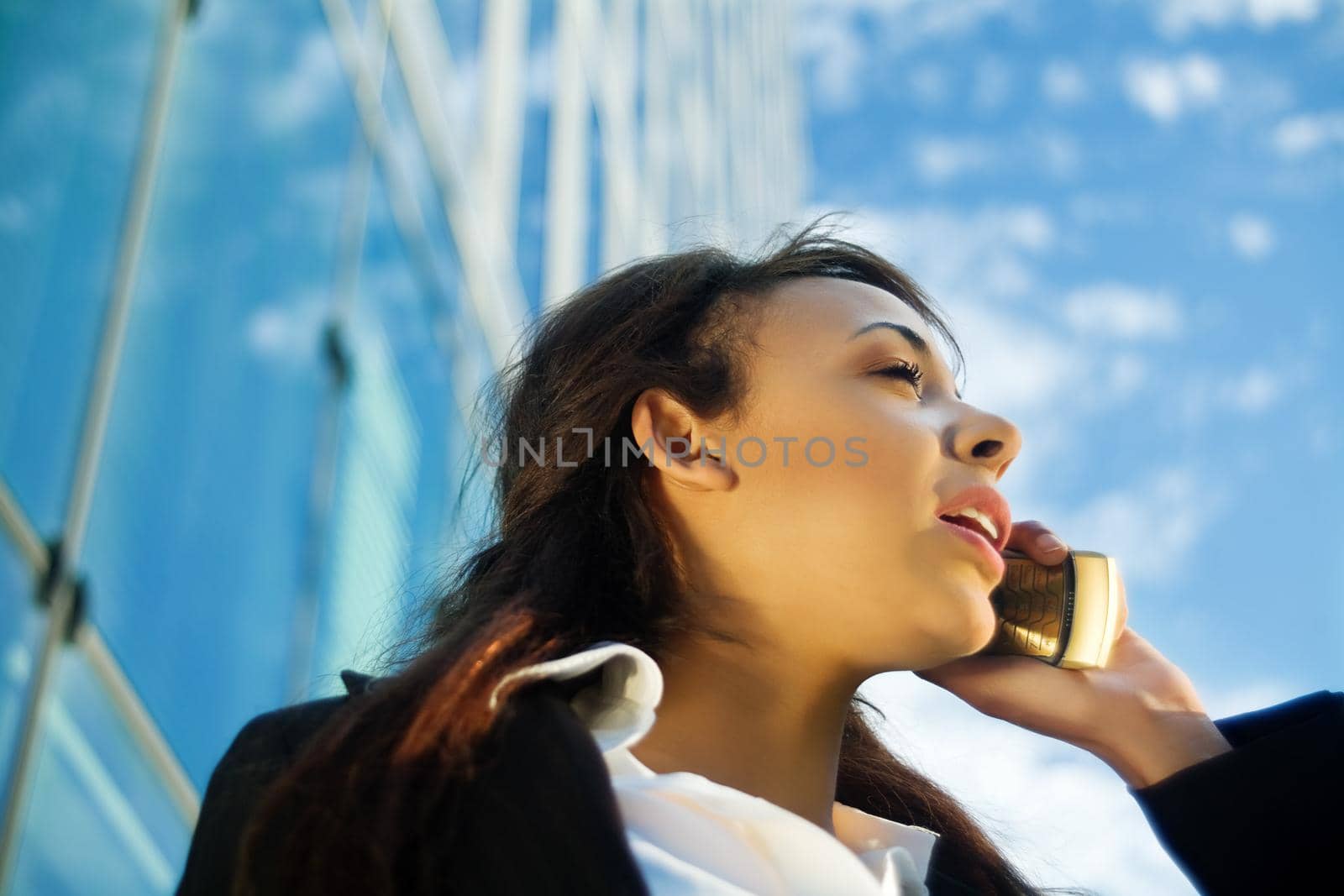 Young female professional using phone outside her office