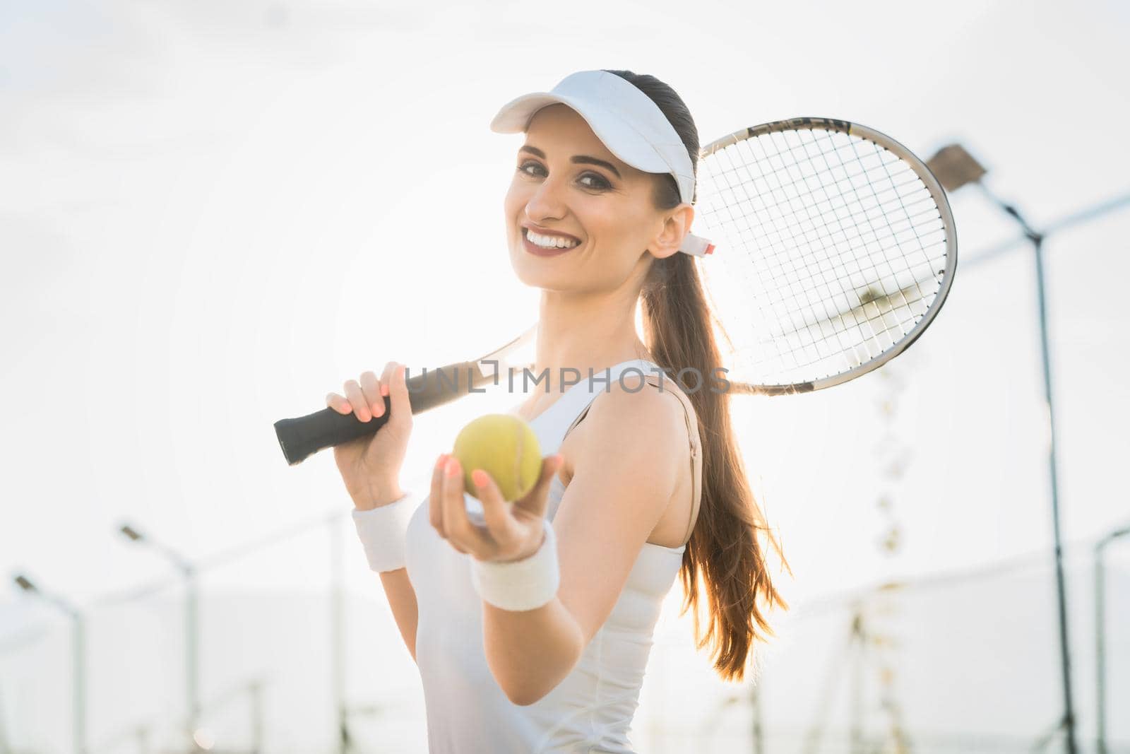 Woman going about playing Tennis showing the ball